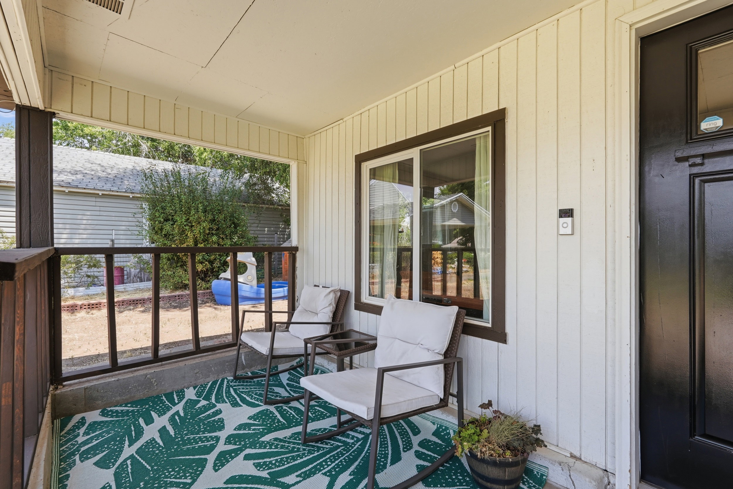 Covered porch with wood-look siding and a dark brown trim window
