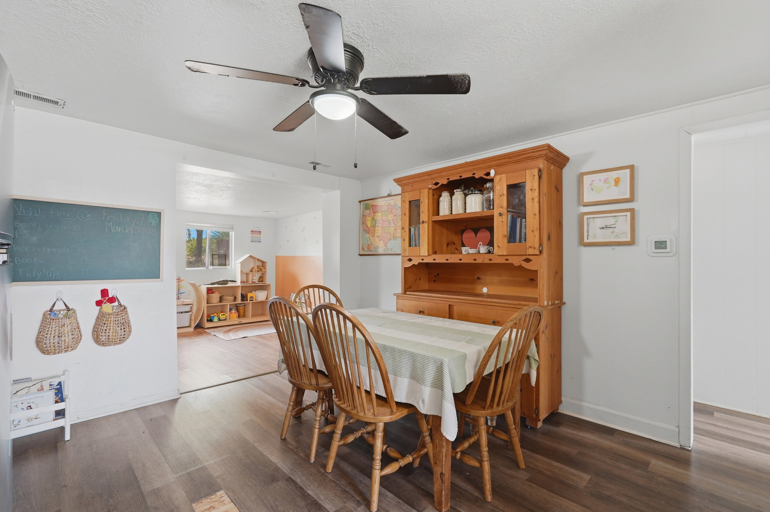 Dining area with wood-finish flooring and a ceiling fan with integrated lighting