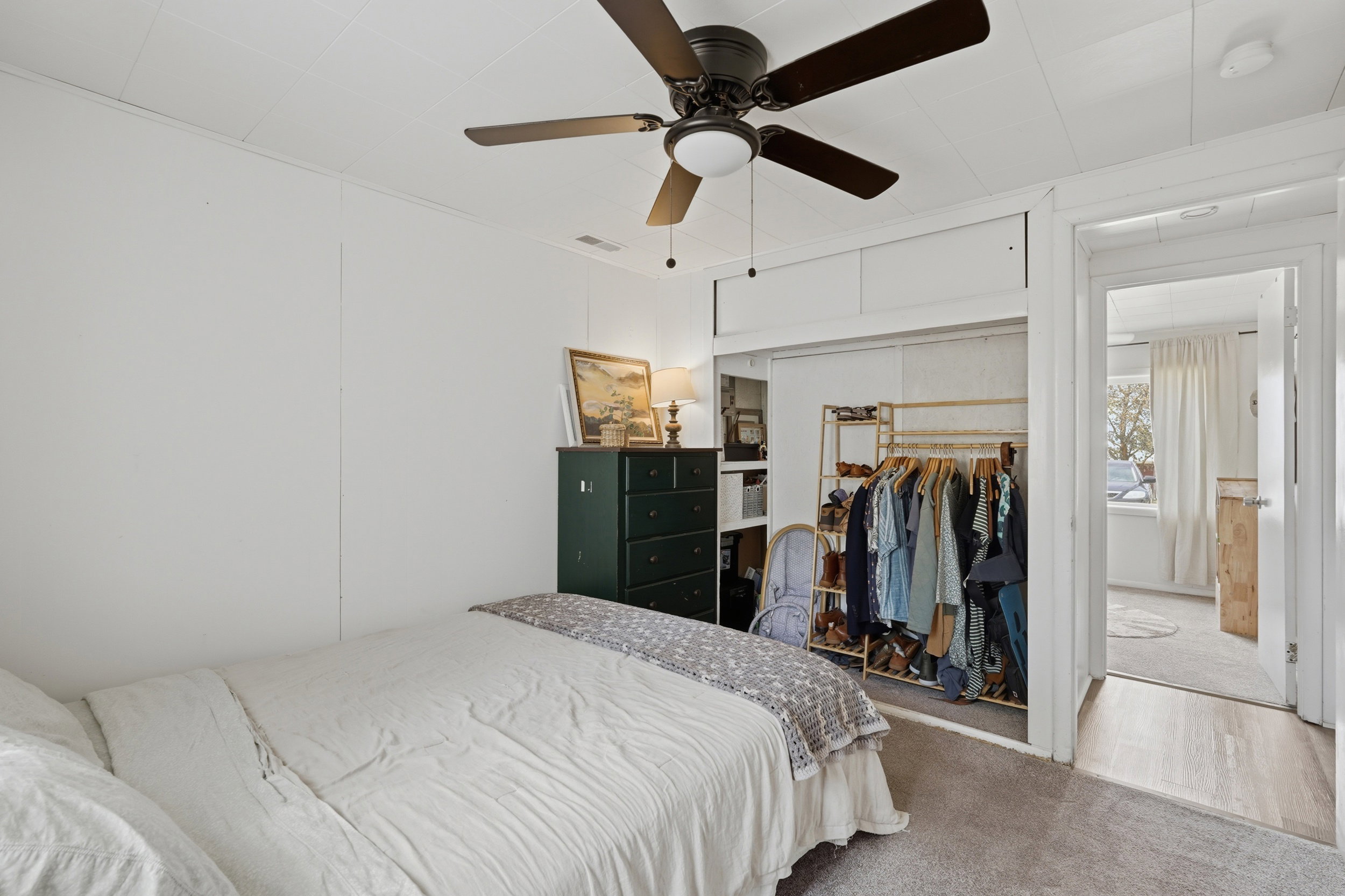 Bedroom featuring a neutral carpet flooring and white paneled walls