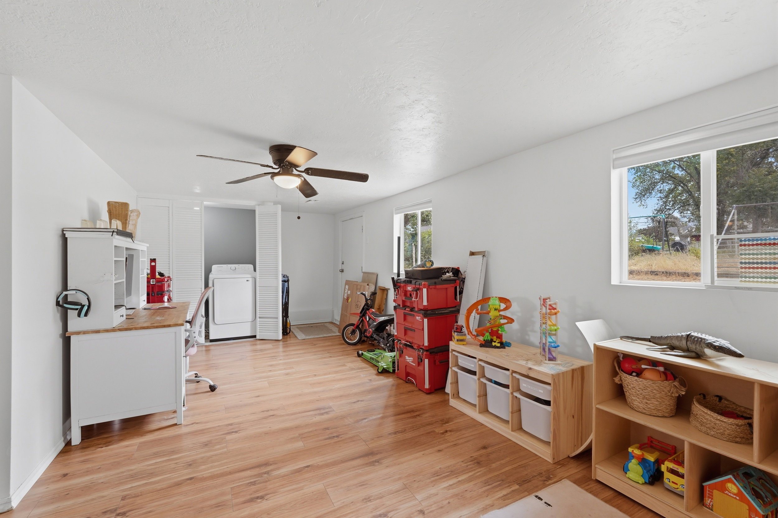 Spacious room featuring wood-finish flooring and a ceiling fan