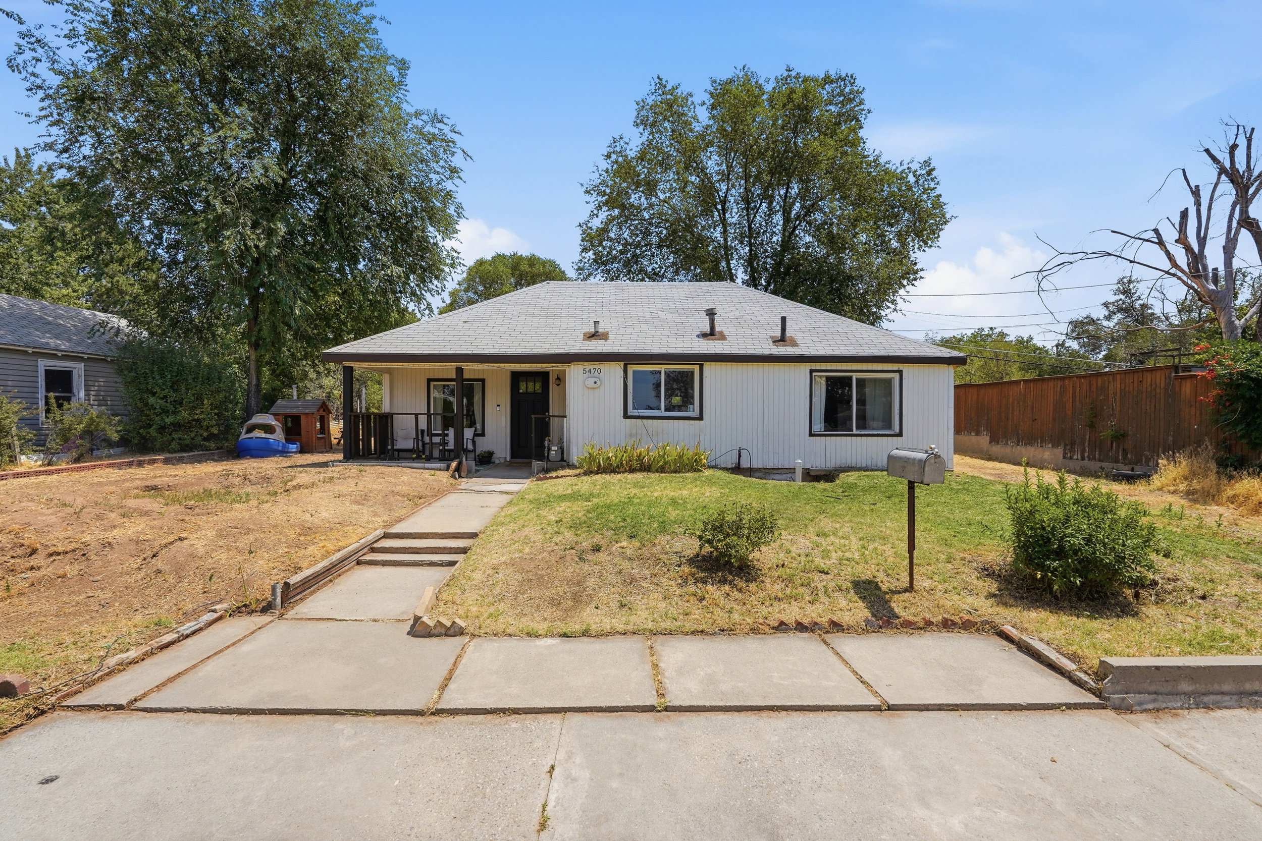 Single-story home featuring a covered front porch, white siding, and a gabled roof