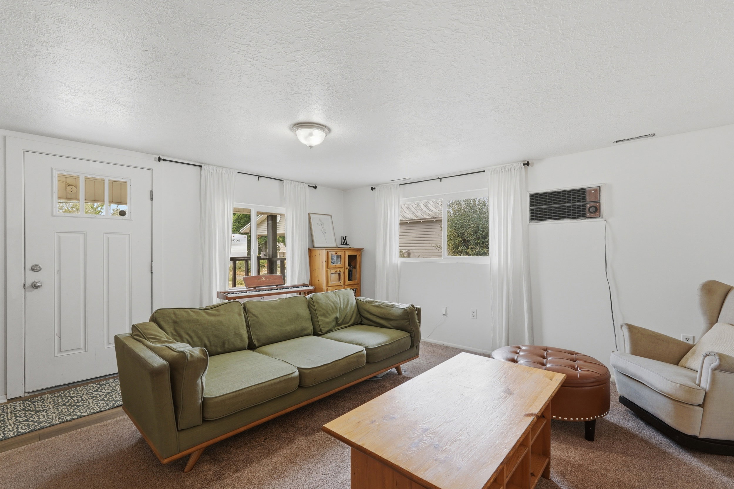 Living area featuring light brown carpet flooring and white painted walls