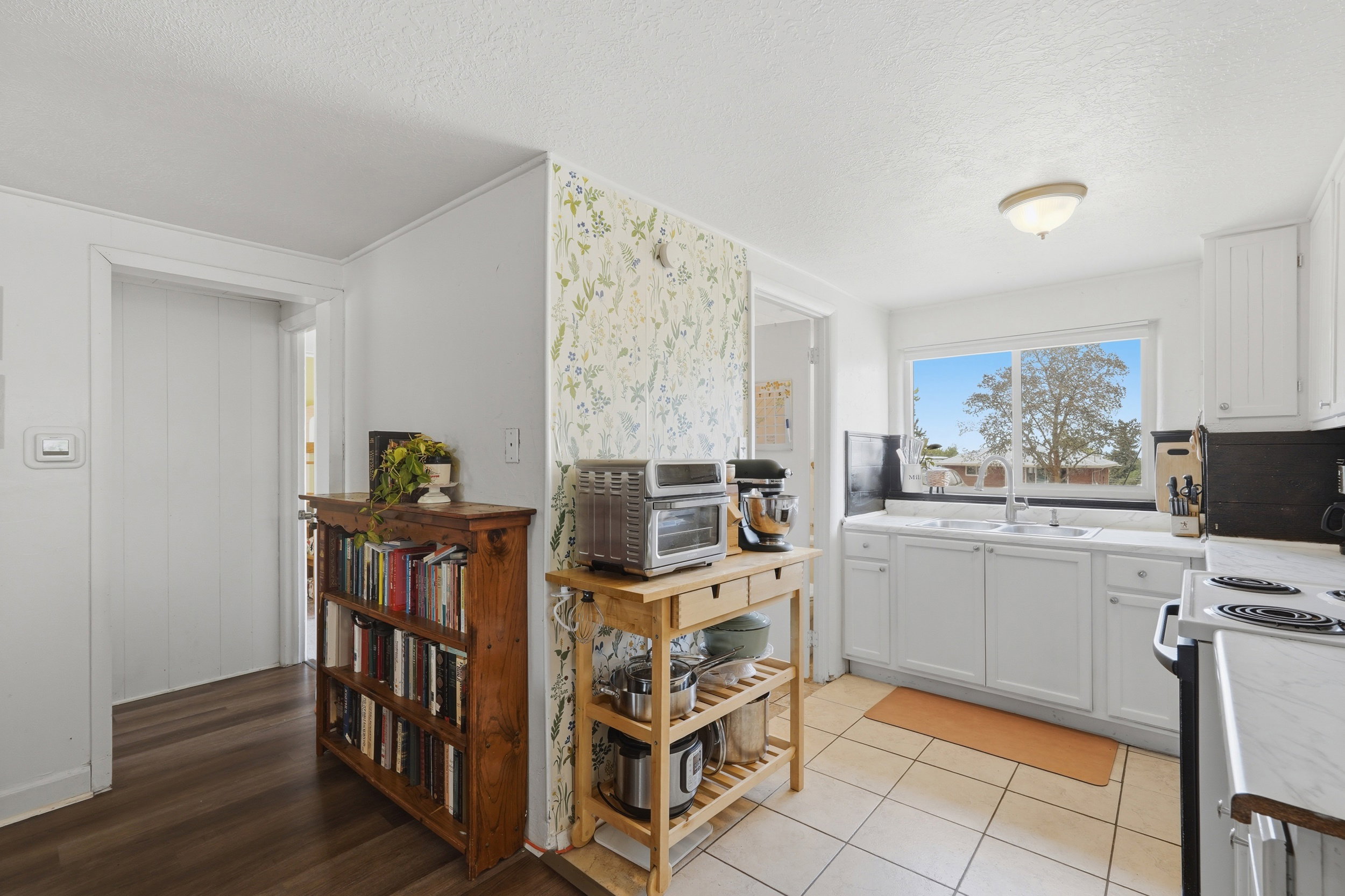 Kitchen featuring white cabinetry, a double basin sink, and a window with outdoor scenery