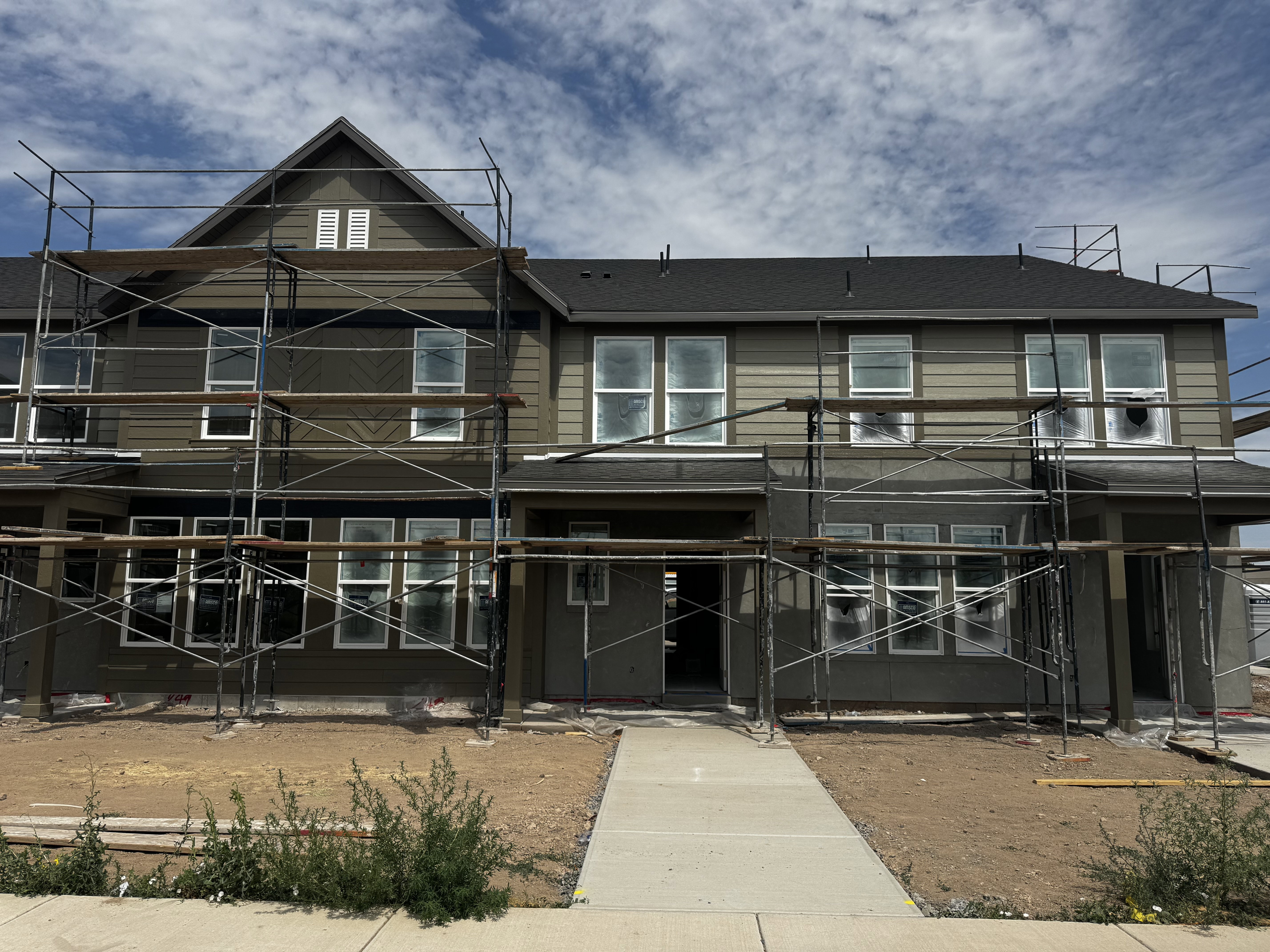 Contemporary multi-story facade featuring horizontal siding and dark shingle roofing