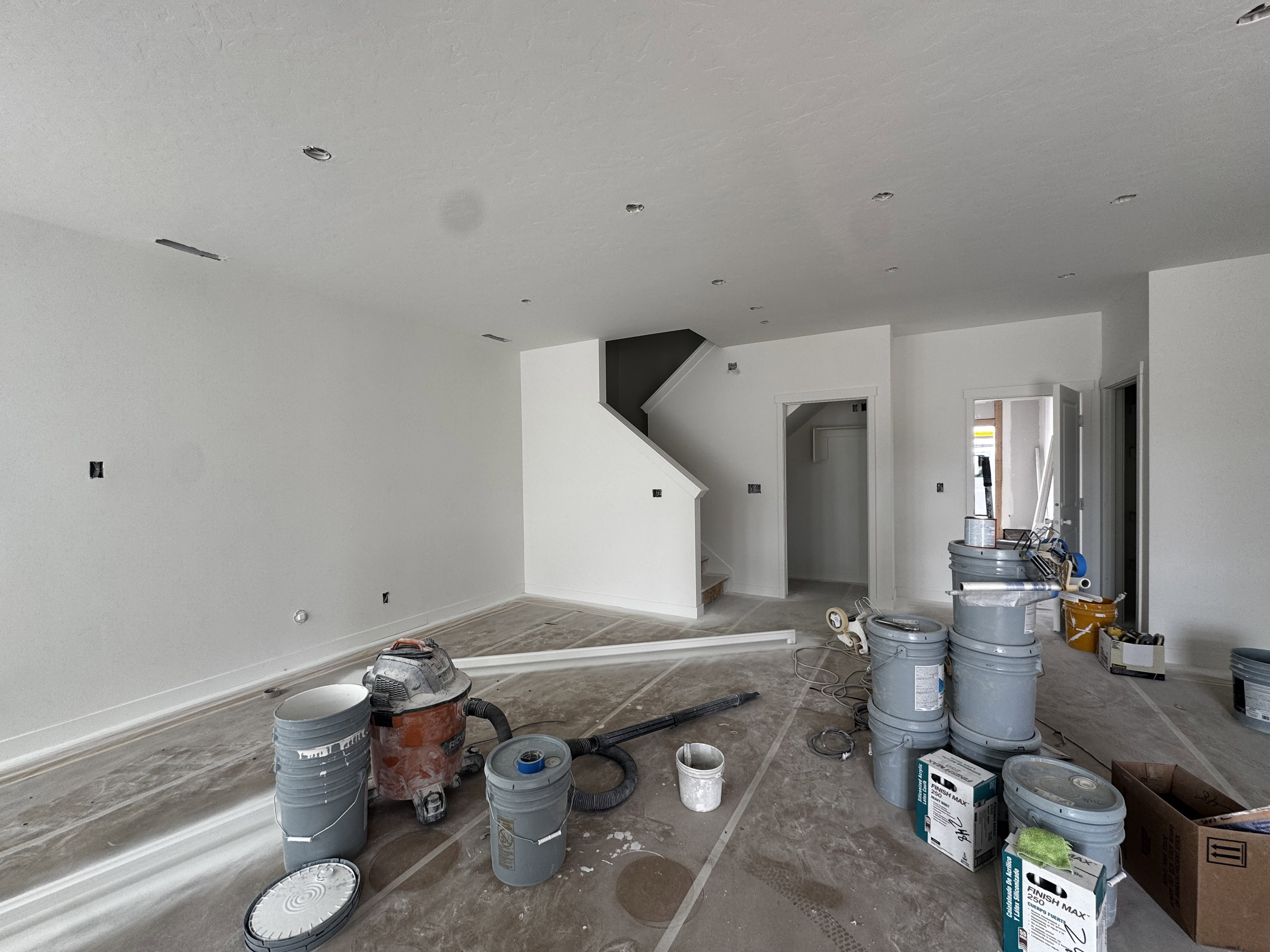 Spacious interior featuring fresh white paint, recessed ceiling lighting, and a prominent staircase