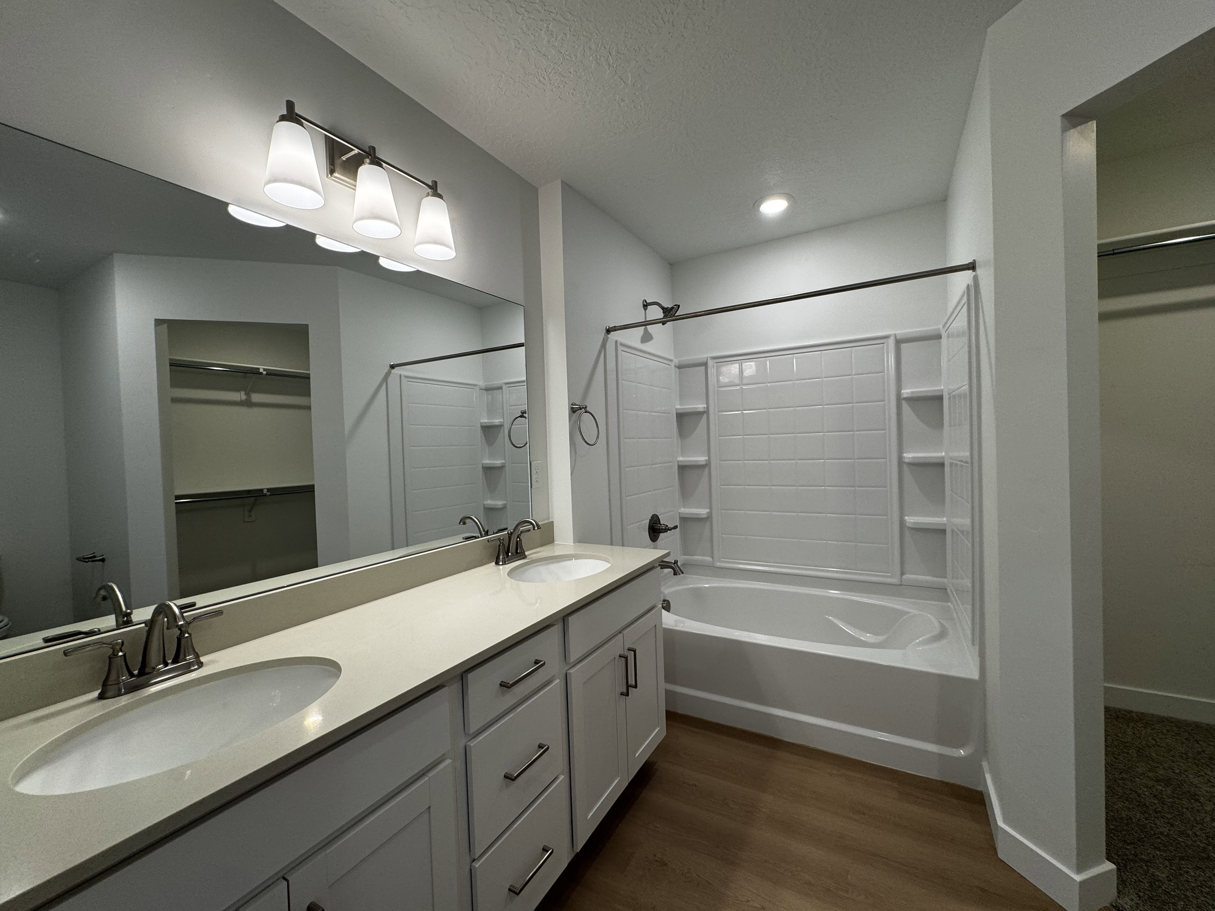 Bathroom featuring a dual vanity with undermount sinks and light-toned countertops