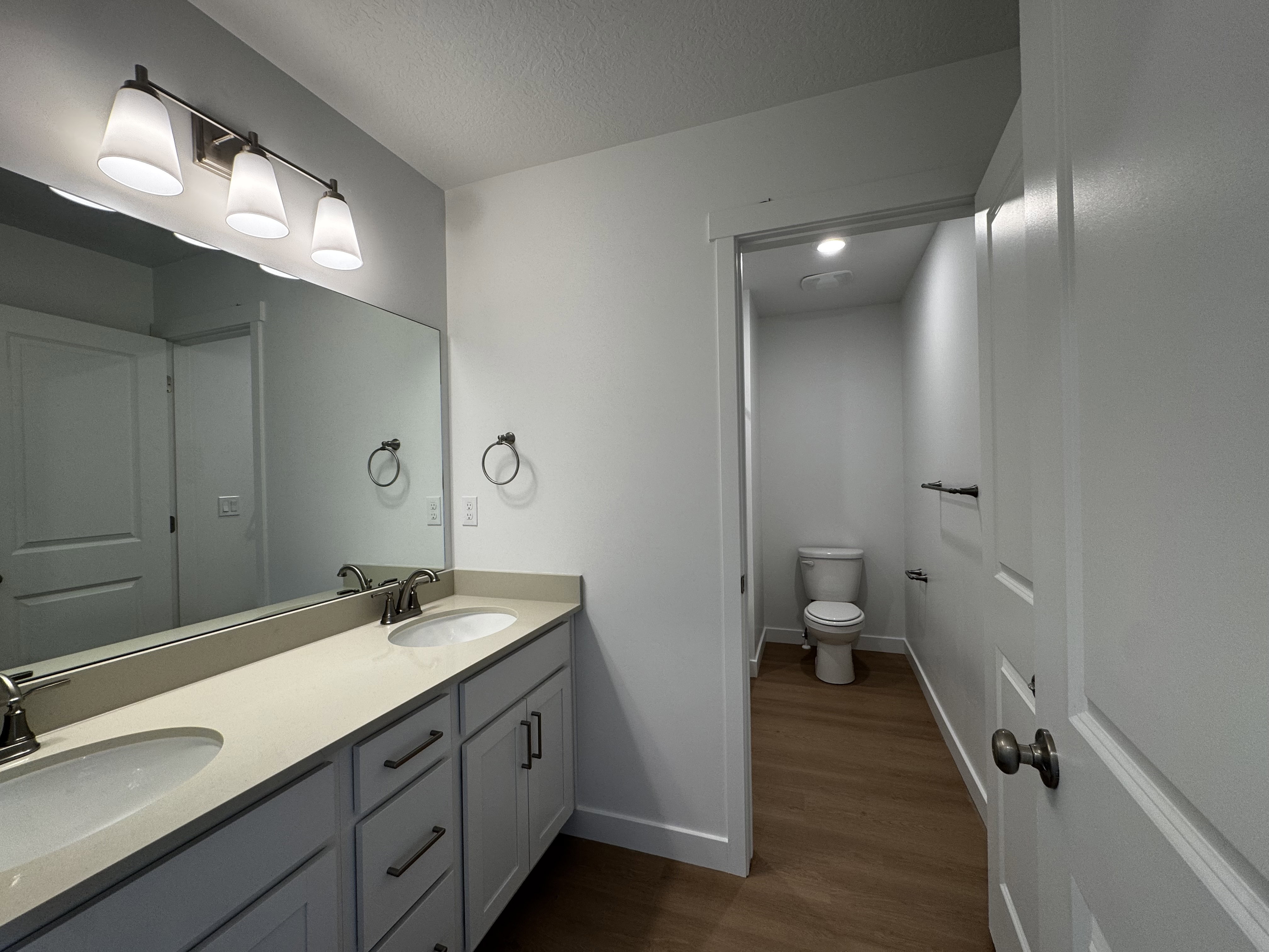 Dual vanity with integrated sinks, light-toned countertop, and brushed nickel hardware