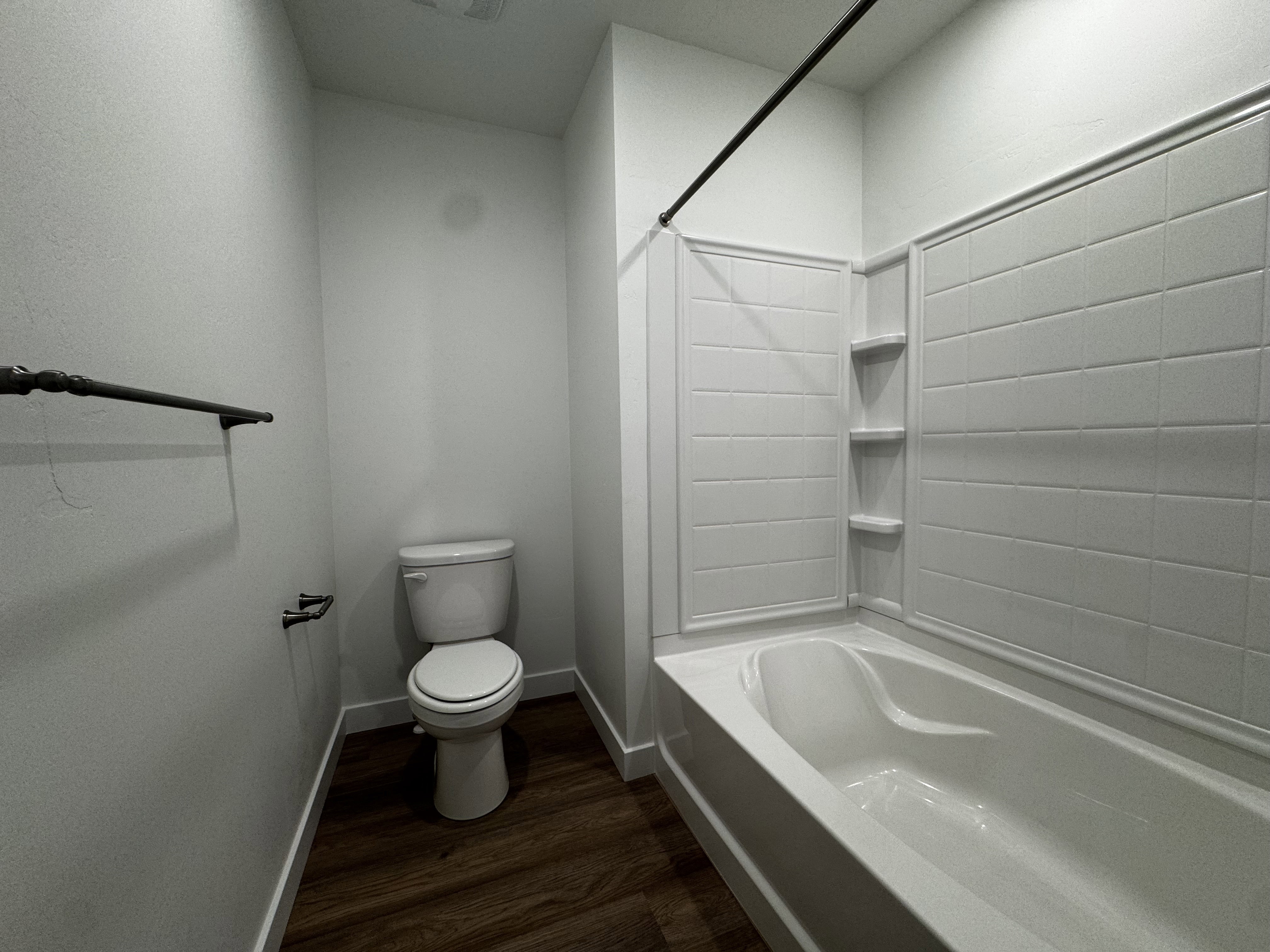 Bathroom featuring a white tub and shower surround with integrated shelving