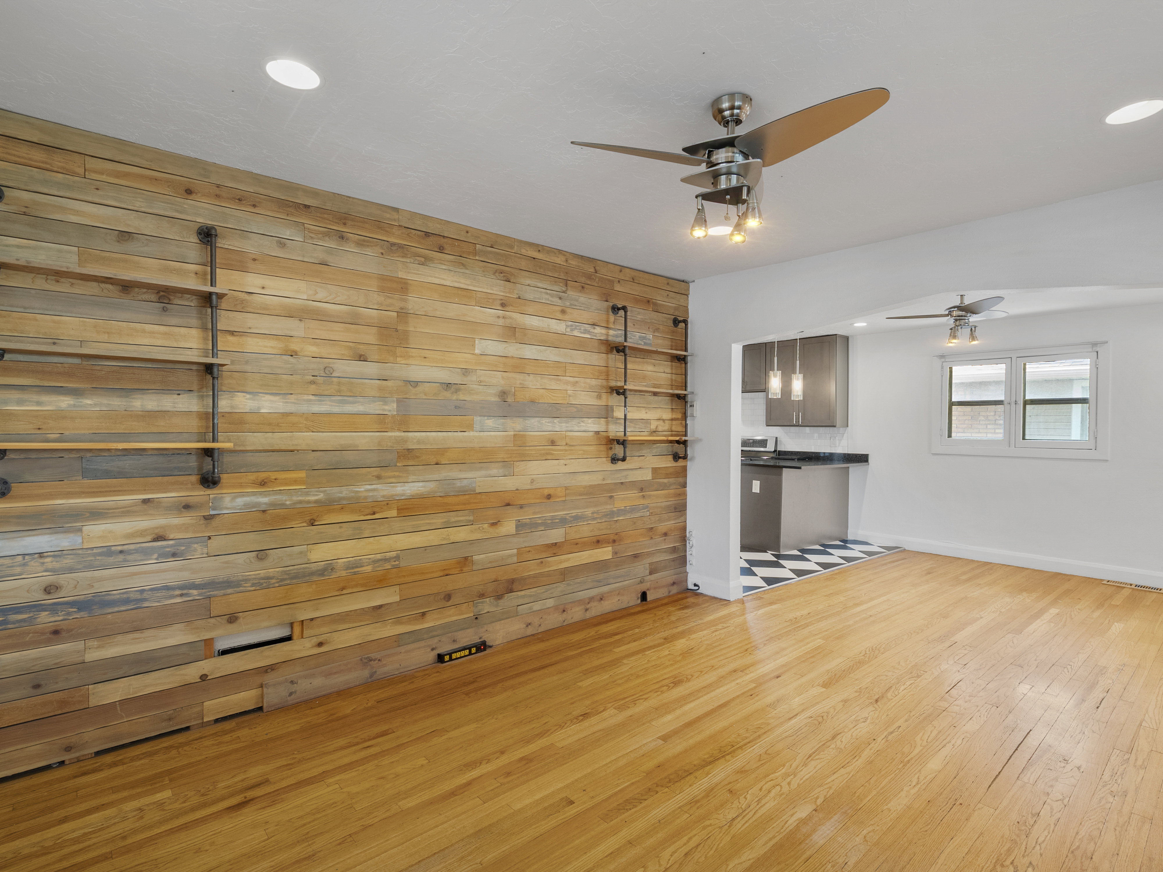 Accent wall featuring wood-paneling and industrial-style shelving