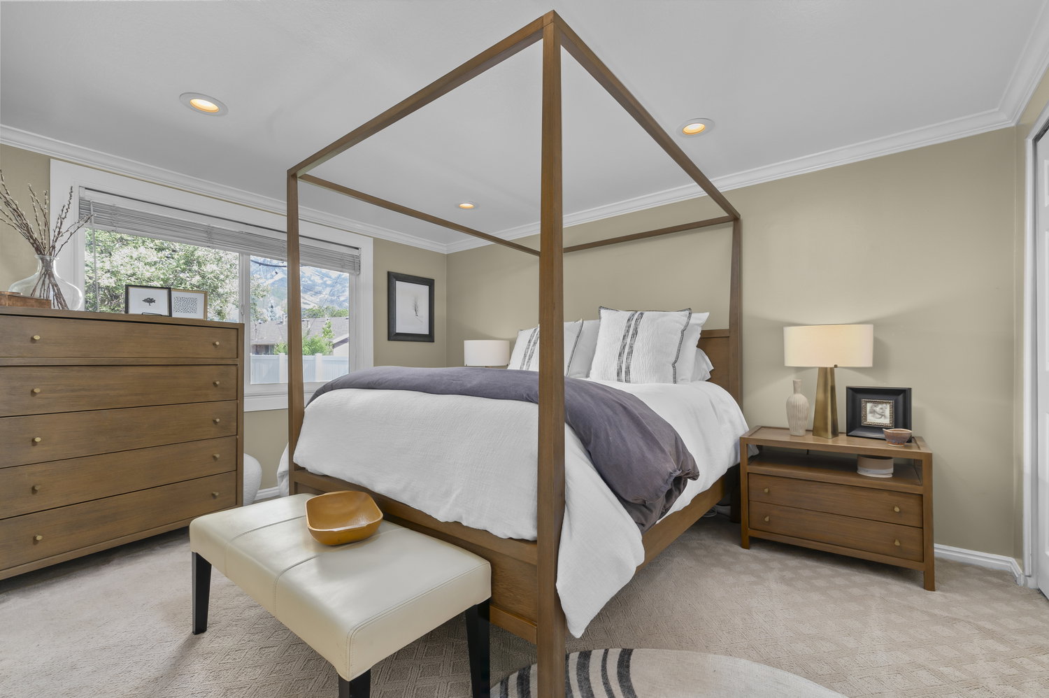 Recessed lighting illuminates neutral-toned walls and crown molding