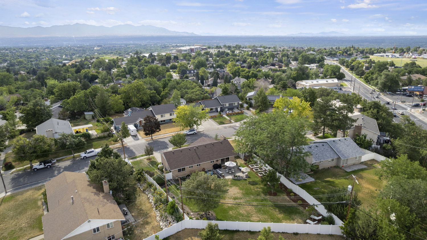 Expansive residential neighborhood with mature trees and a distant mountain range backdrop