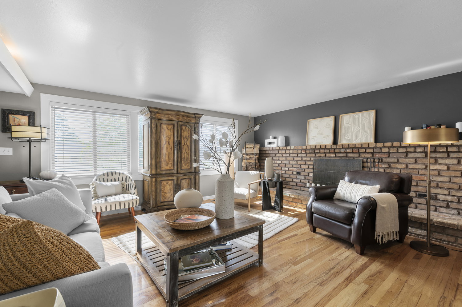 Spacious living area featuring wood-finish flooring and a brick fireplace