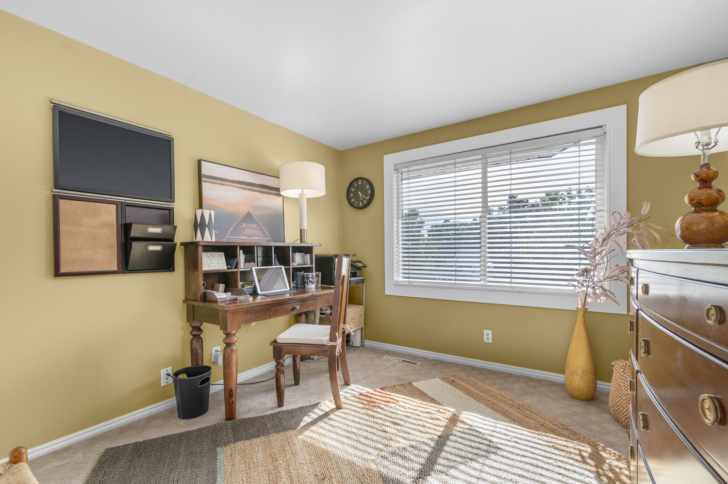 Carpeted room with a large window featuring horizontal blinds