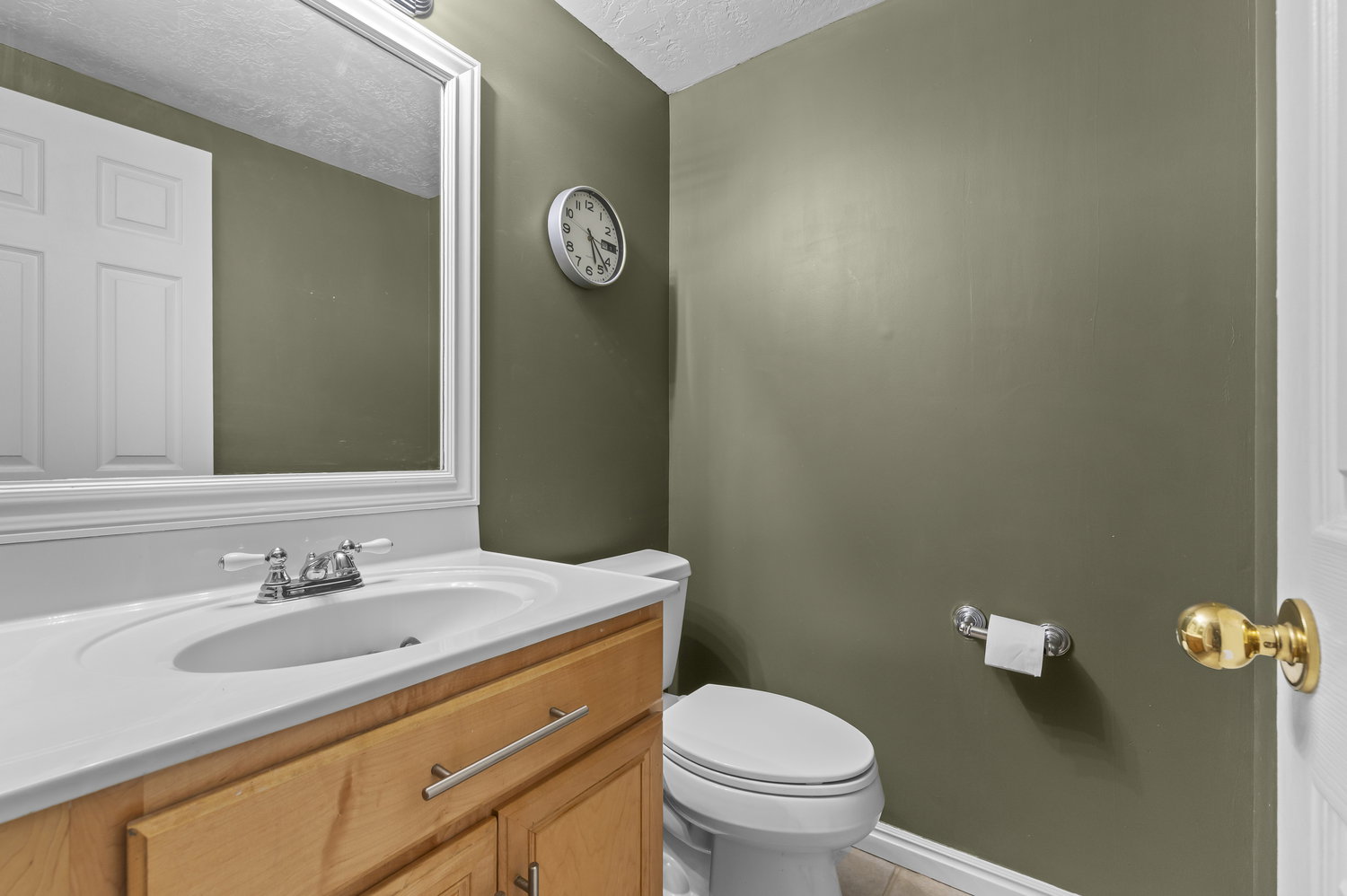 Vanity with a light wood finish, white countertop, and integrated sink