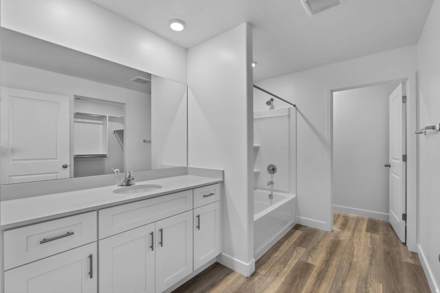 Bathroom featuring a spacious vanity with white cabinetry and a light-toned countertop