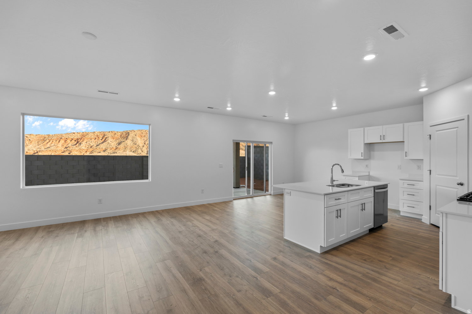 Open-concept living space featuring wood-finish flooring and recessed lighting throughout
