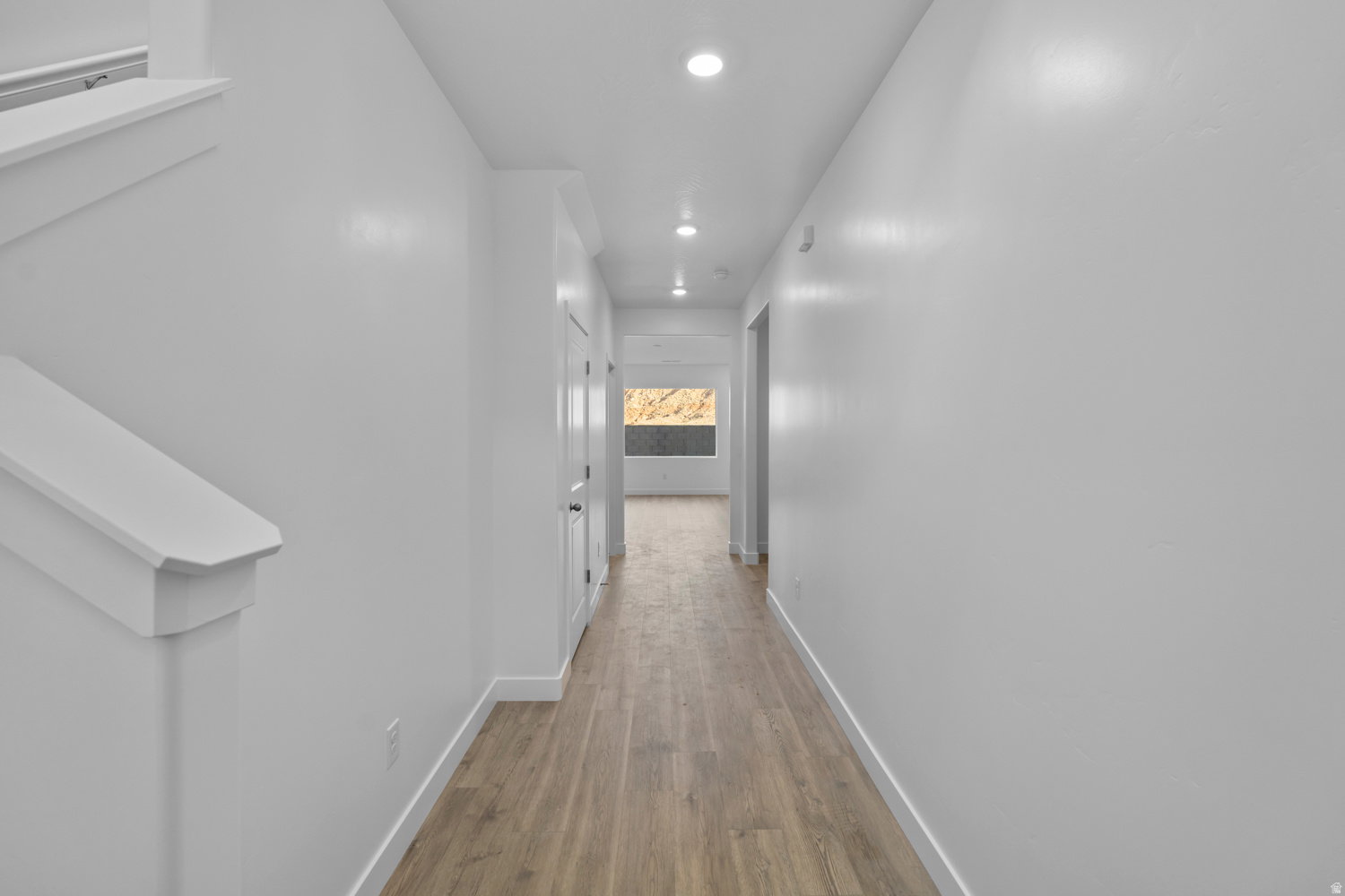Entryway featuring wood-finish flooring, recessed lighting, white trim, and a staircase with white balustrade
