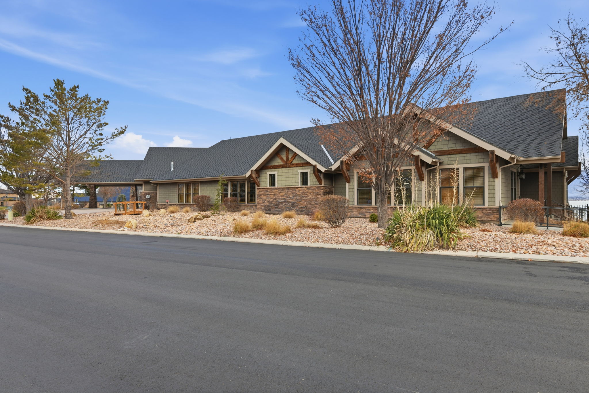 Craftsman-style exterior featuring stone accents, horizontal siding, and exposed rafter tails