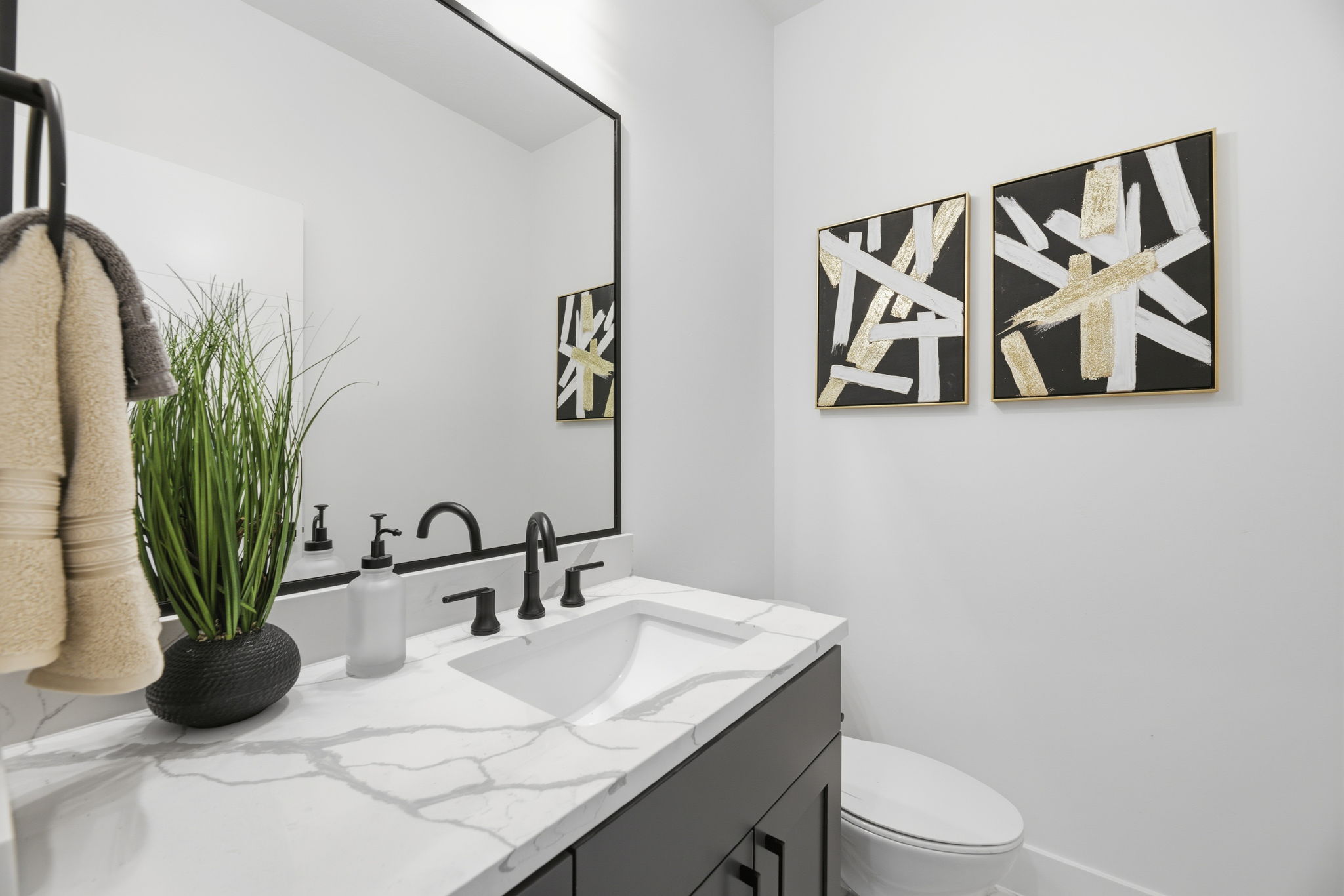 Vanity featuring a rectangular undermount sink, a white countertop with grey veining, and a matte black faucet
