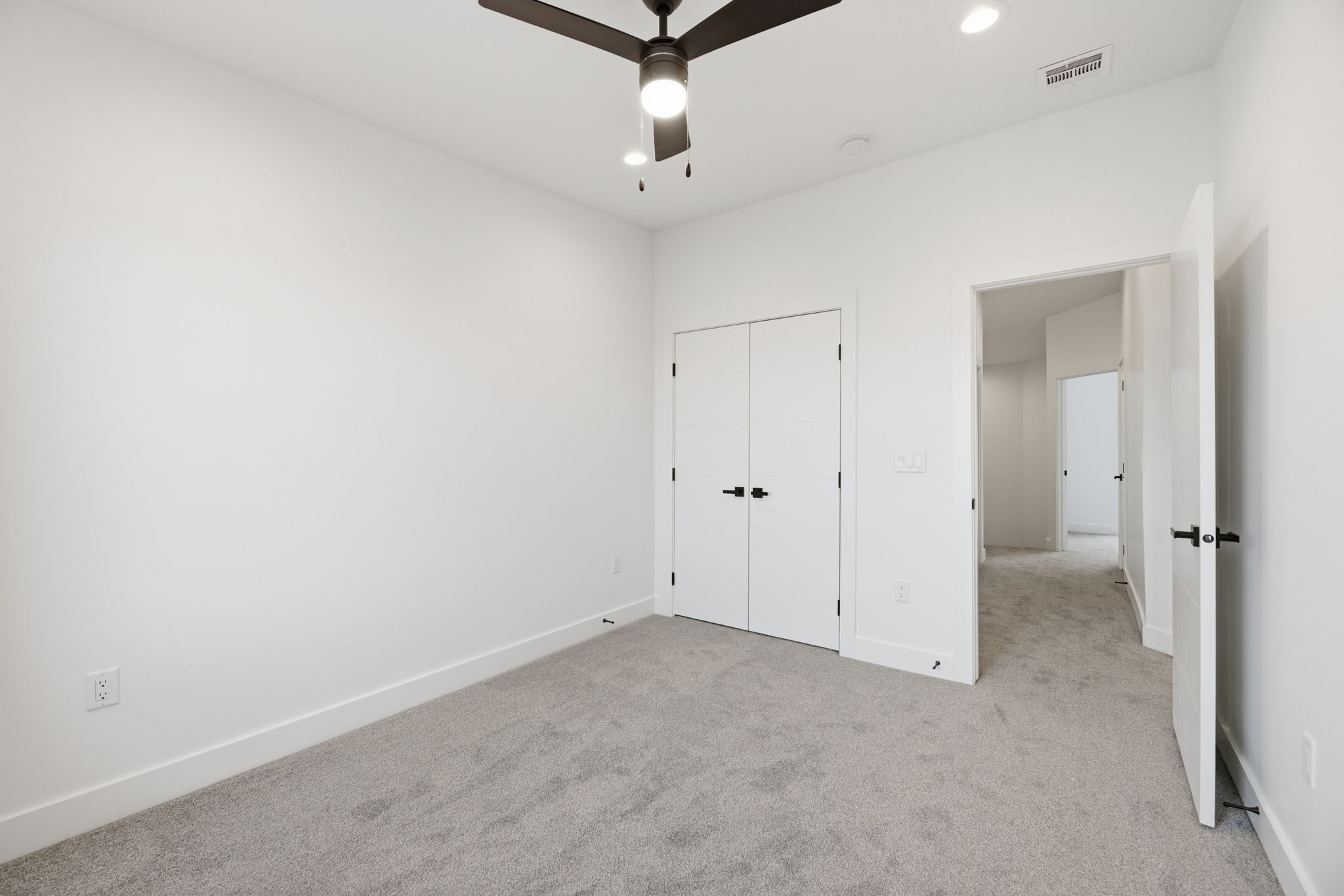 Carpeted room featuring a ceiling fan with integrated lighting, recessed lighting, double-door closet, and white trim