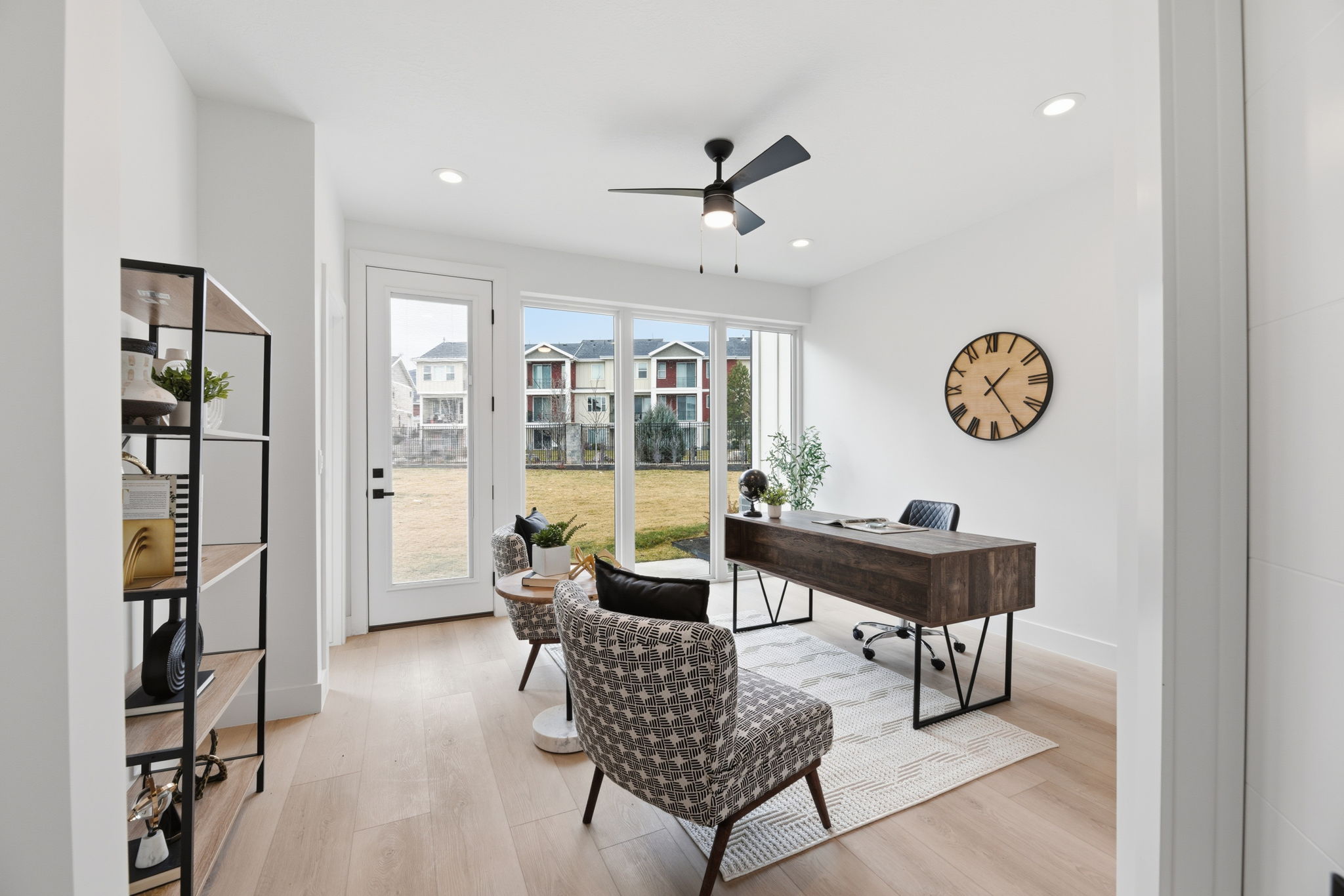 Light-filled room featuring extensive window systems and a glass-paneled exterior door