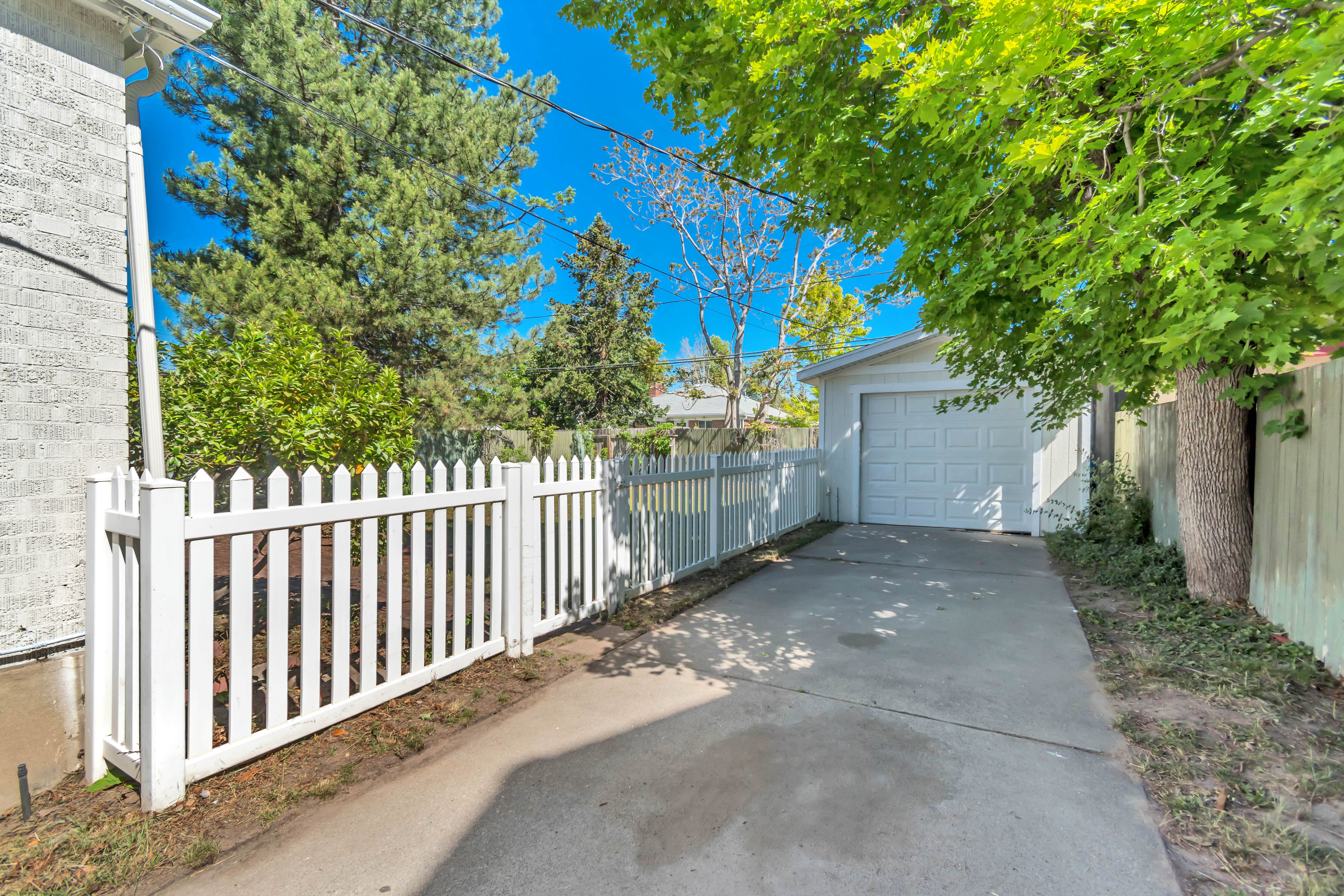 Paved driveway providing direct access to the detached garage with a white panel door