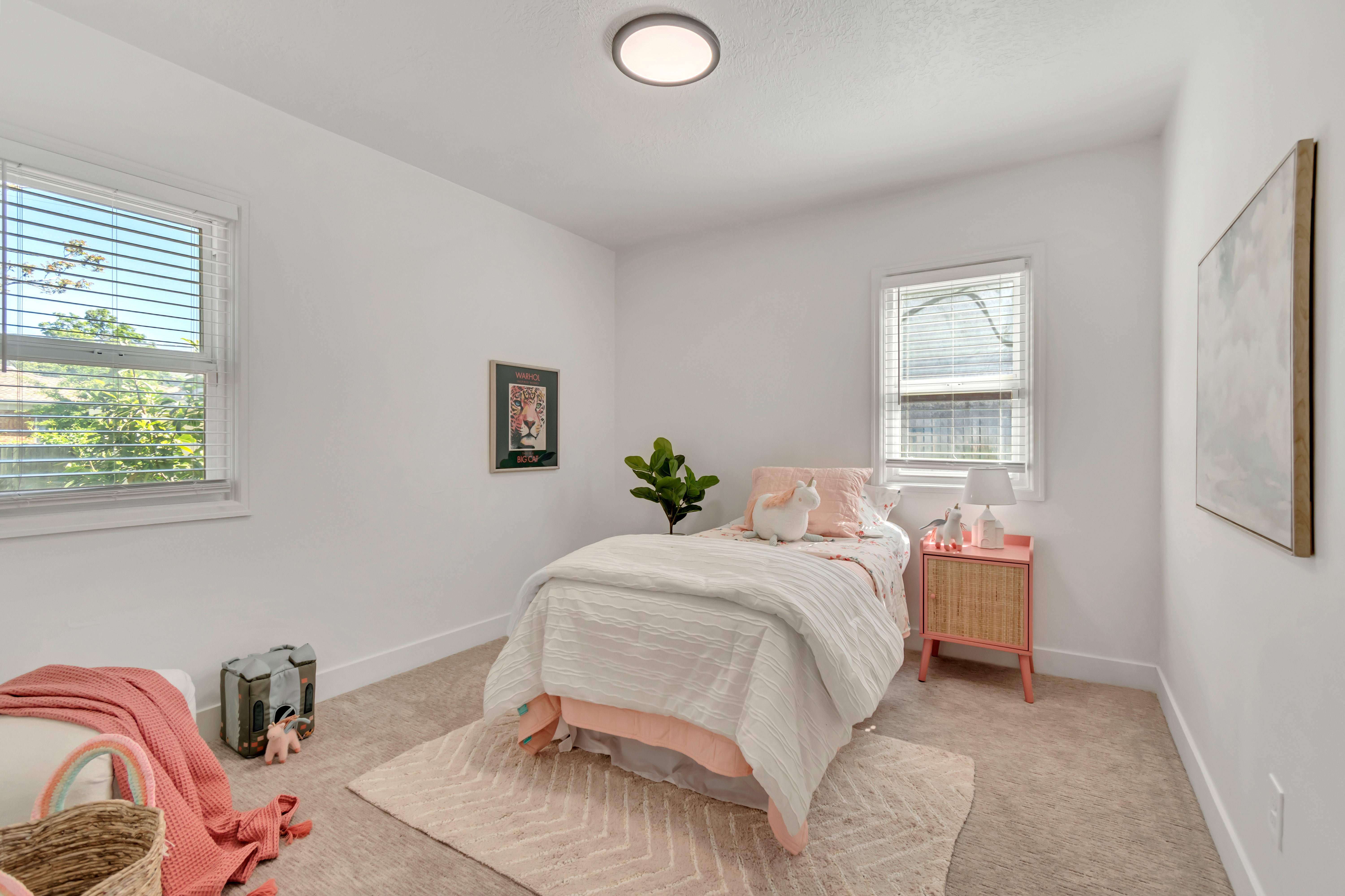 Light-filled room featuring neutral wall paint, carpet flooring, two windows with blinds, and recessed lighting