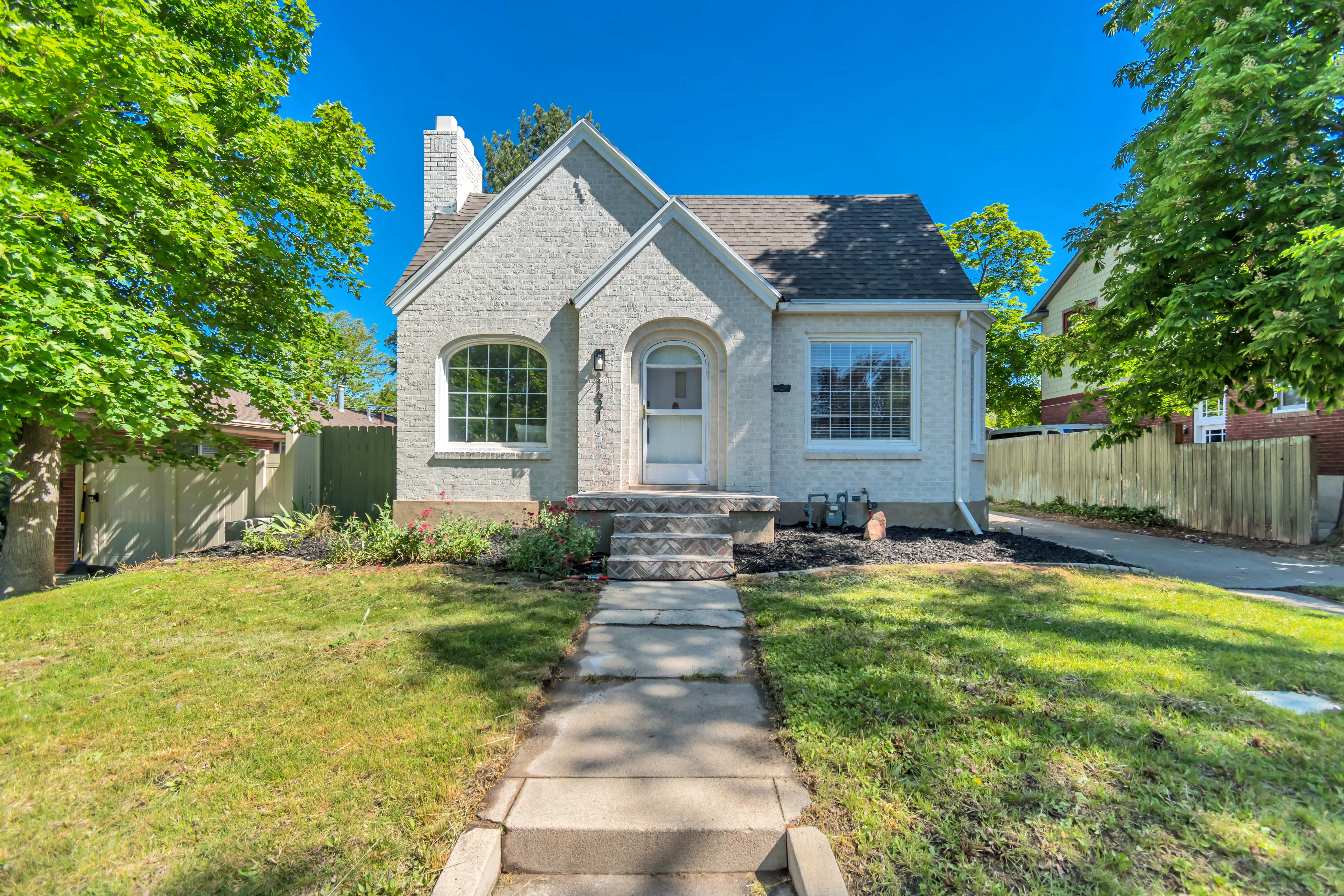 Stucco exterior with a peaked roofline, arched window, and prominent chimney