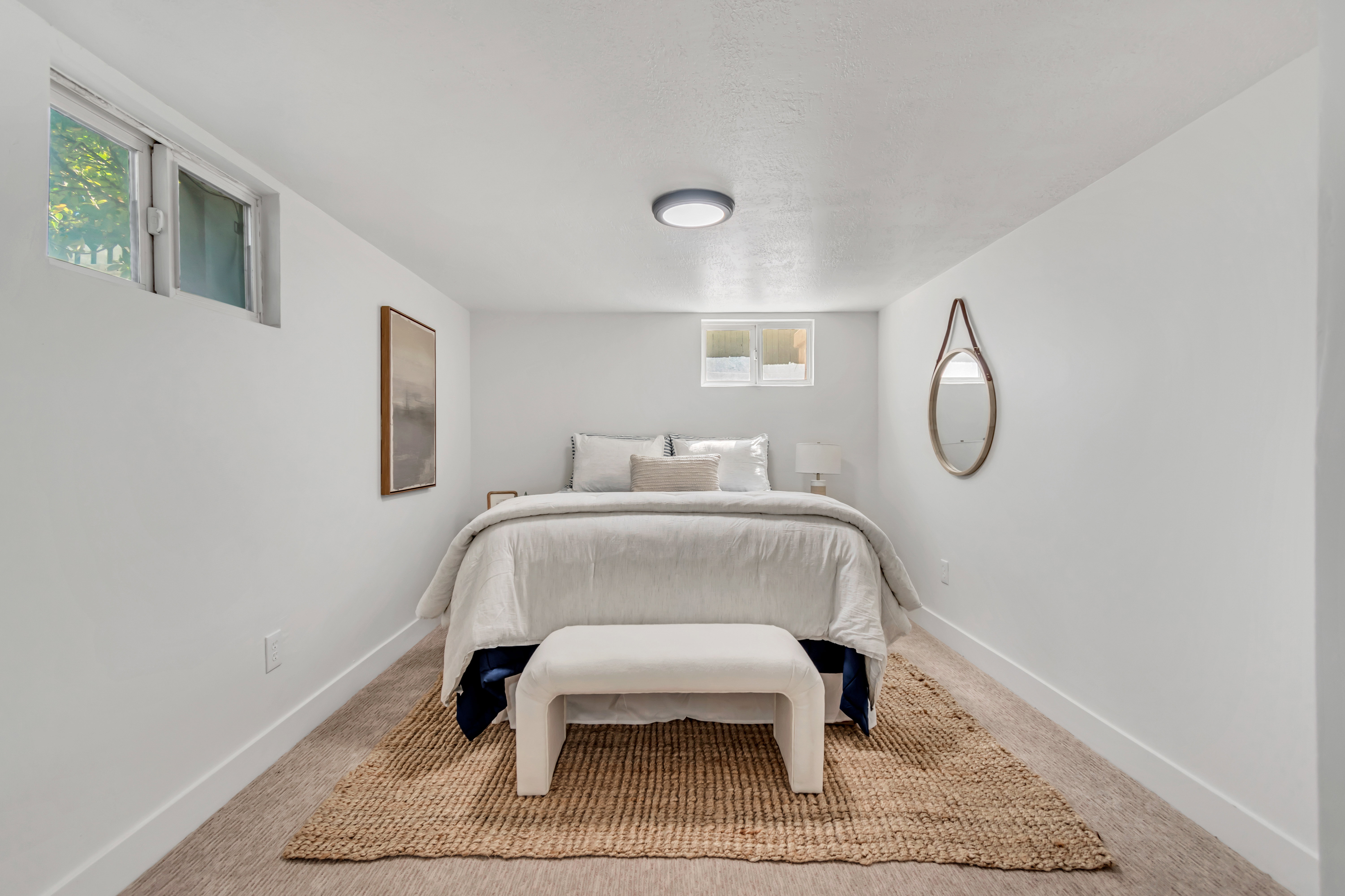 Bright bedroom featuring recessed windows, neutral wall paint, white trim, a flush-mount ceiling light, and carpet flooring