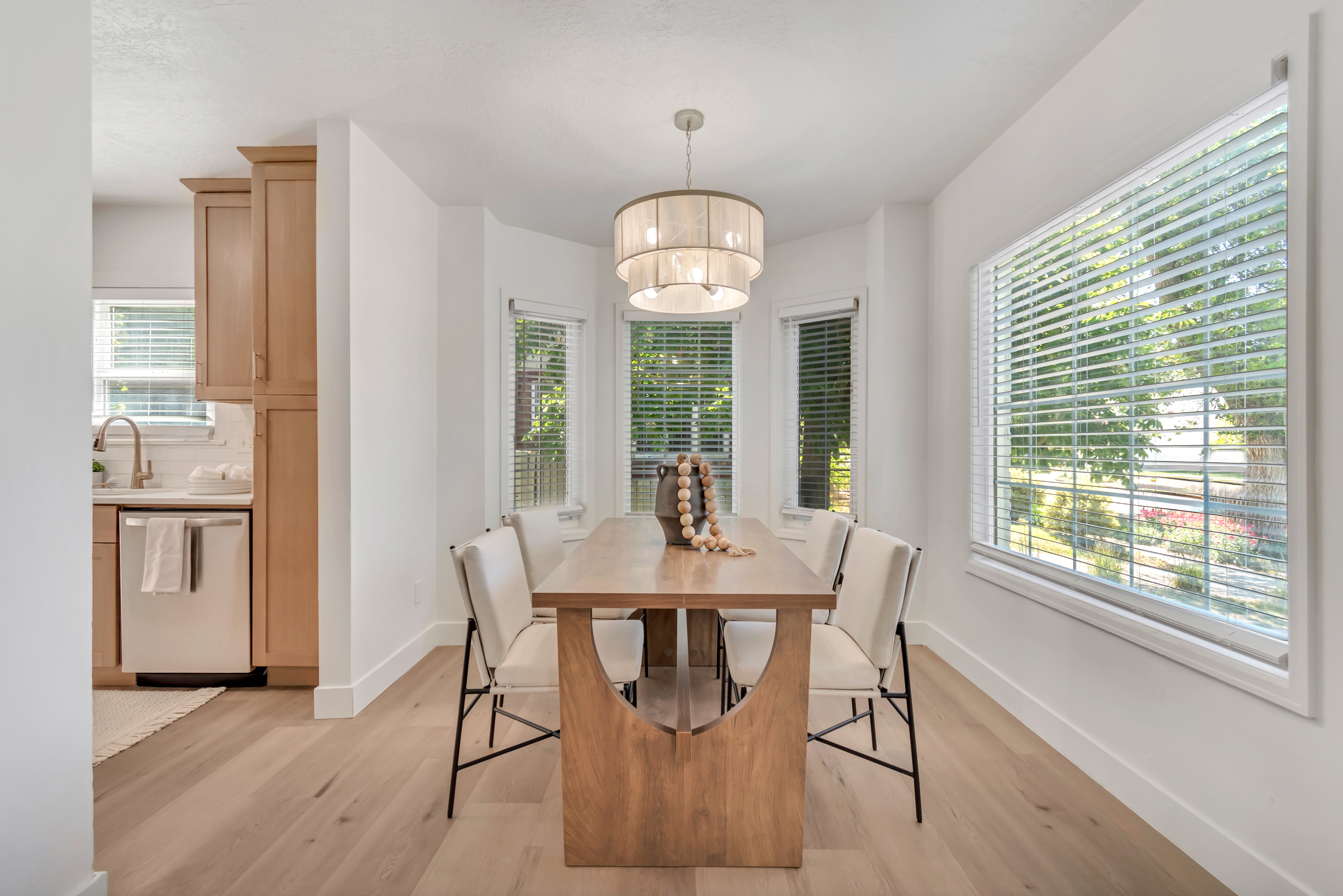Dining area featuring light wood-finish flooring and a contemporary chandelier