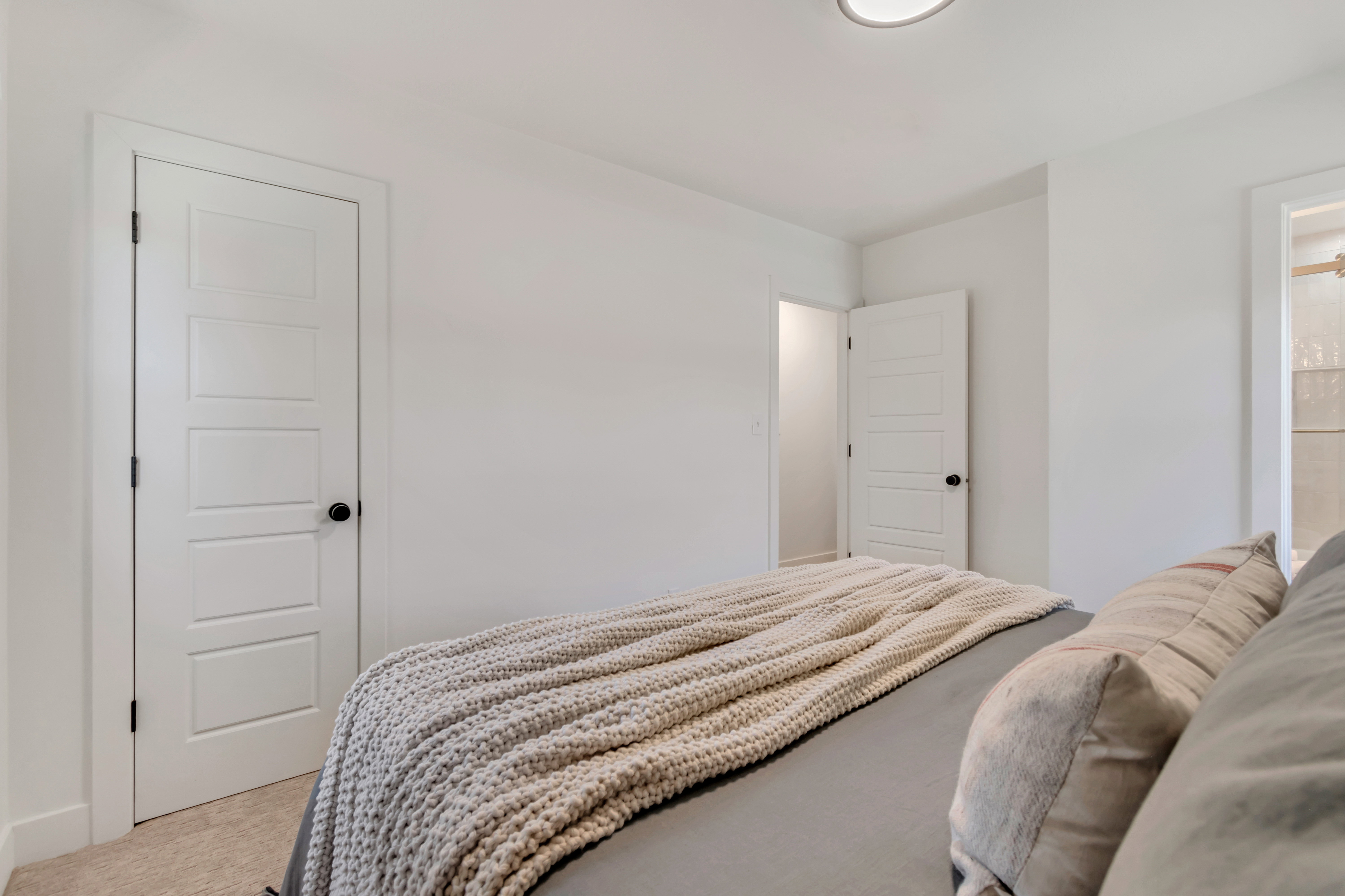 Neutral-toned wall-to-wall carpeting and bright white walls