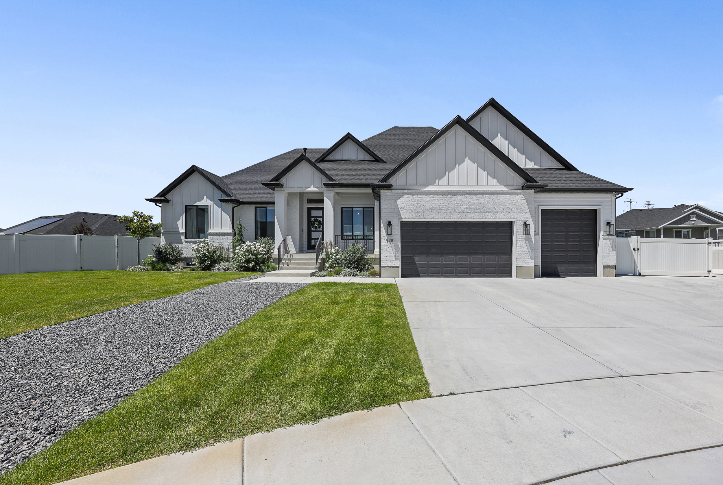 Contemporary ranch-style residence featuring a prominent two-car garage with dark paneled doors