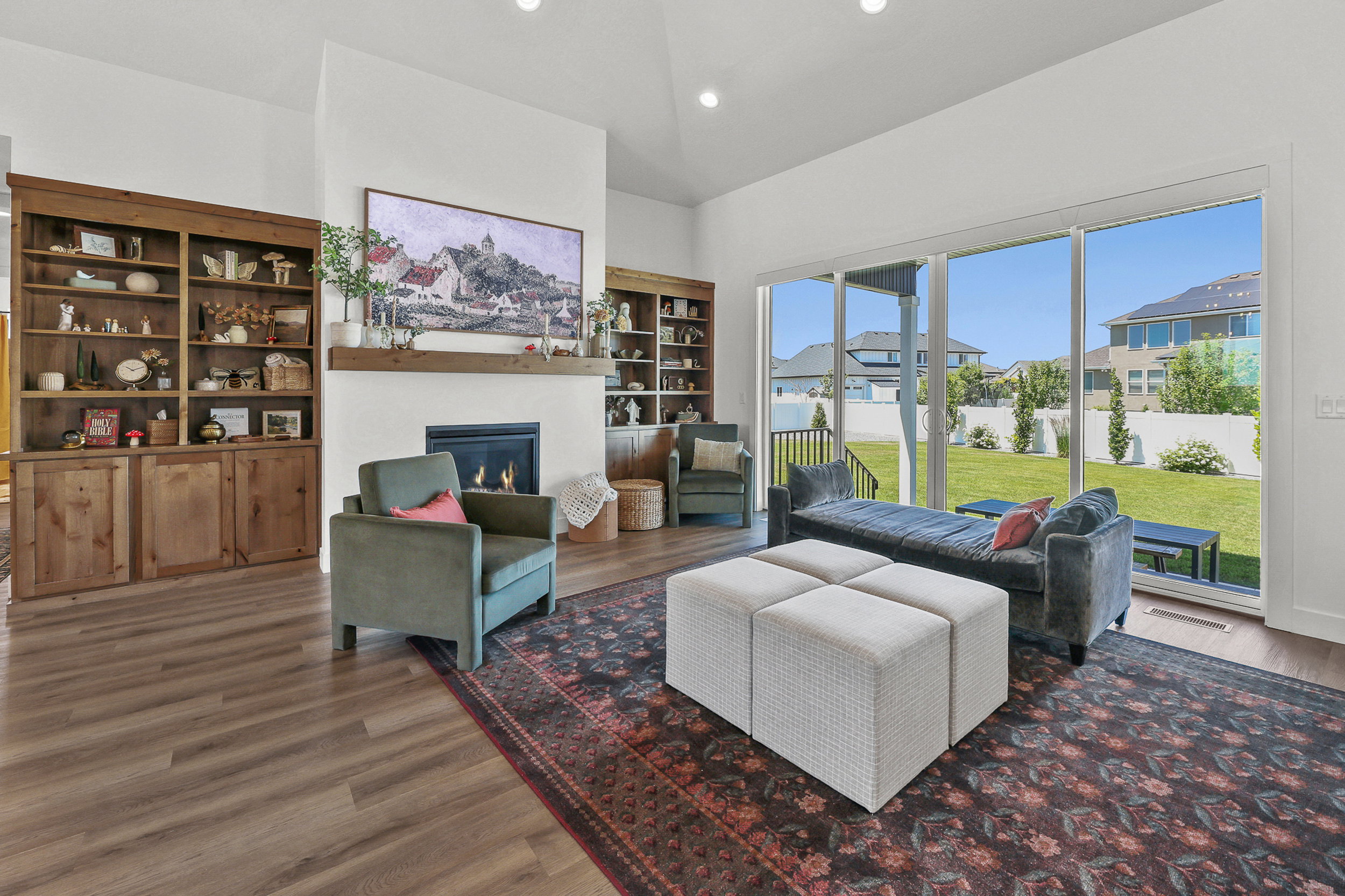 Spacious living area featuring a fireplace with a wood mantle, built-in wooden shelving, and wood-finish flooring