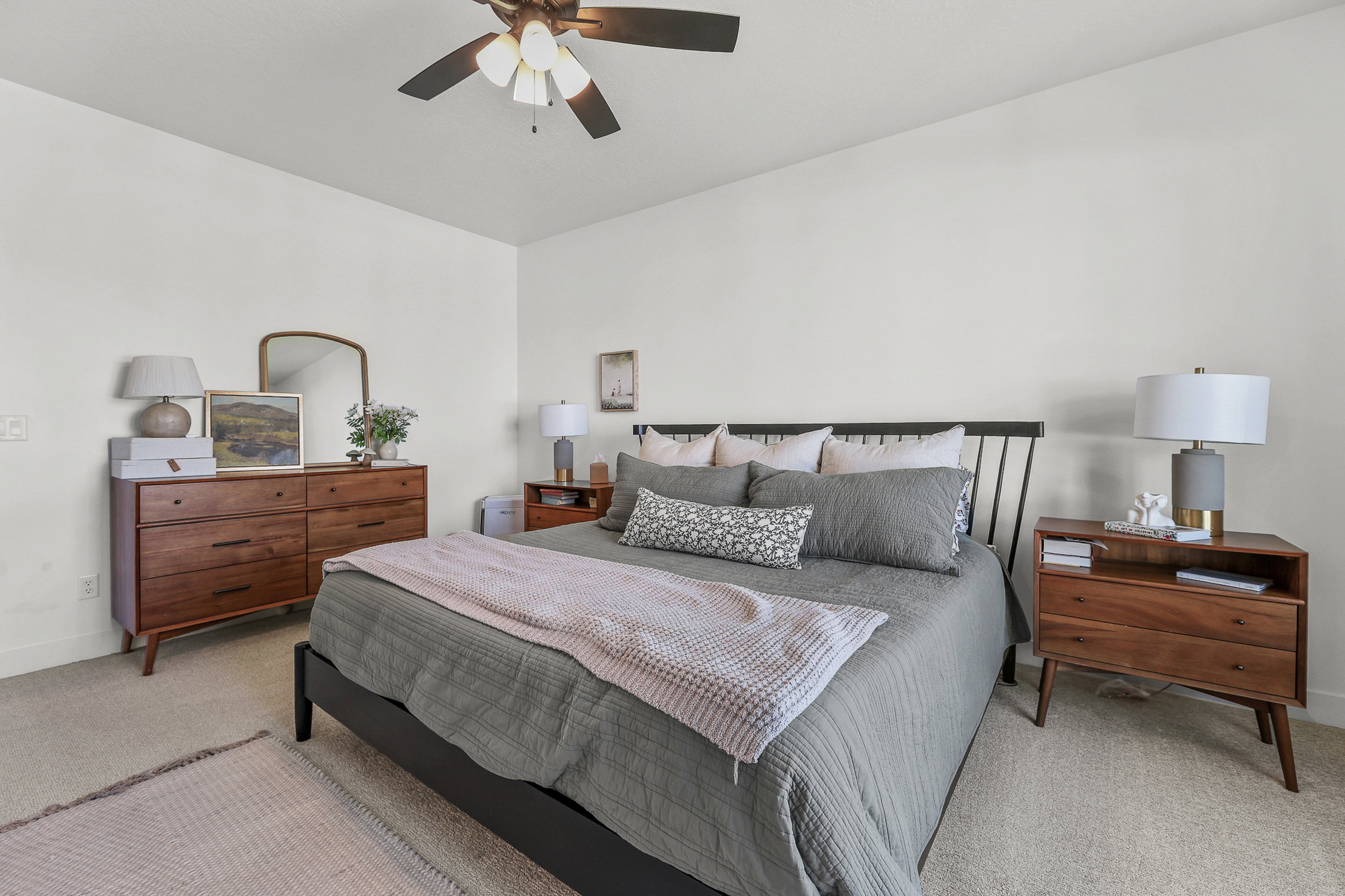 Spacious room featuring neutral carpeting, a ceiling fan with integrated lighting, and ample wall space