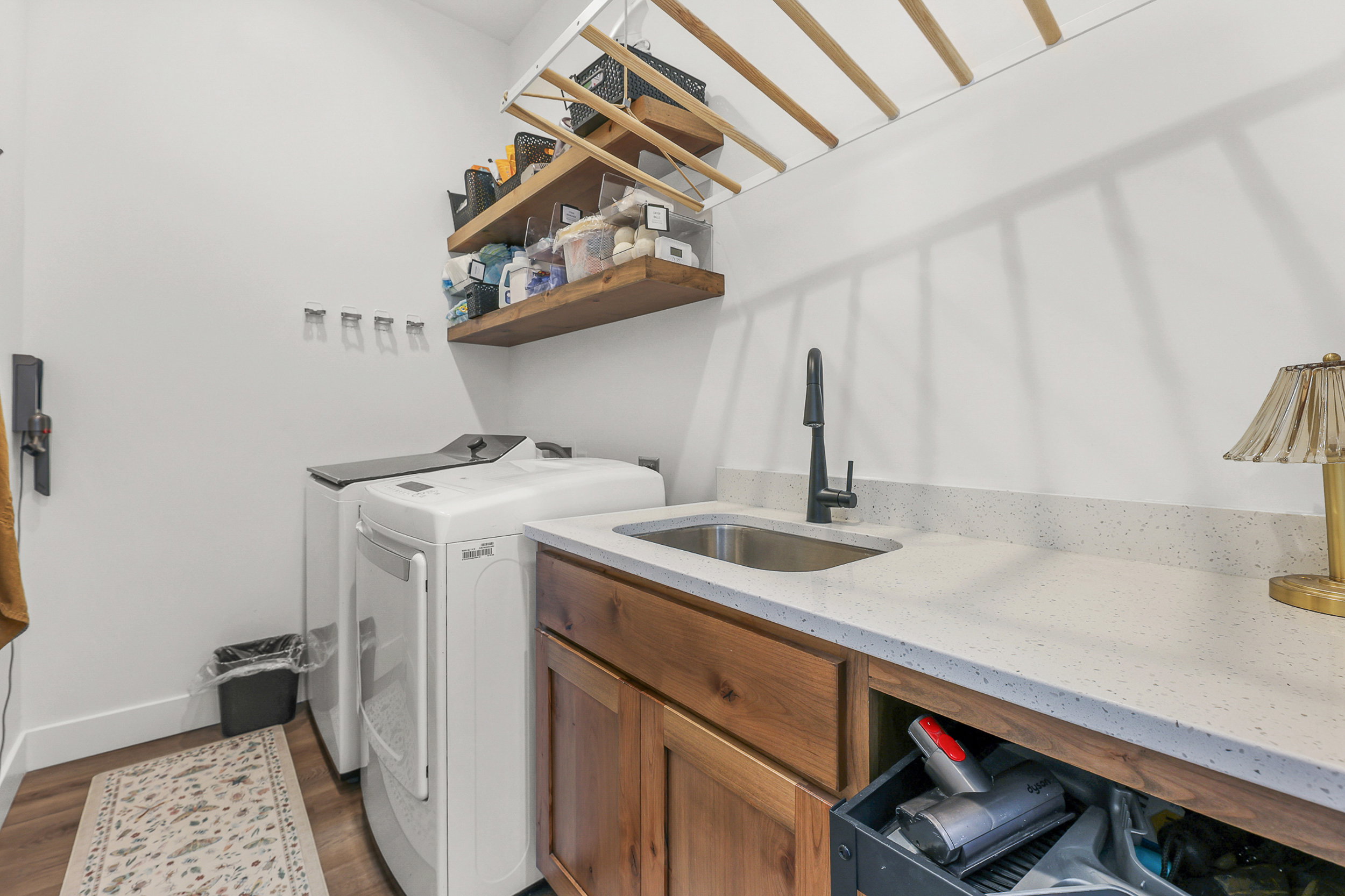 Laundry room featuring wood-finish flooring and white walls