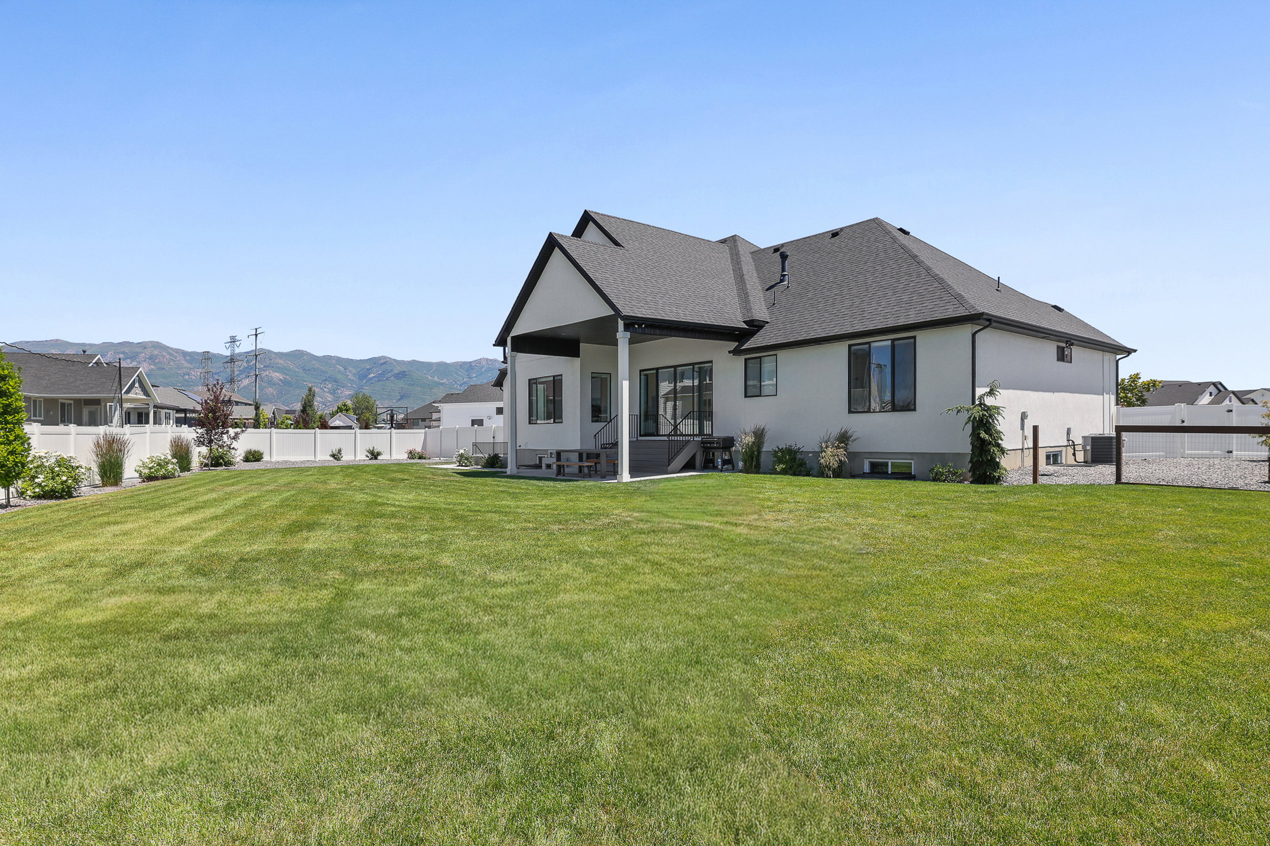 Expansive rear yard featuring a manicured lawn and mature plantings