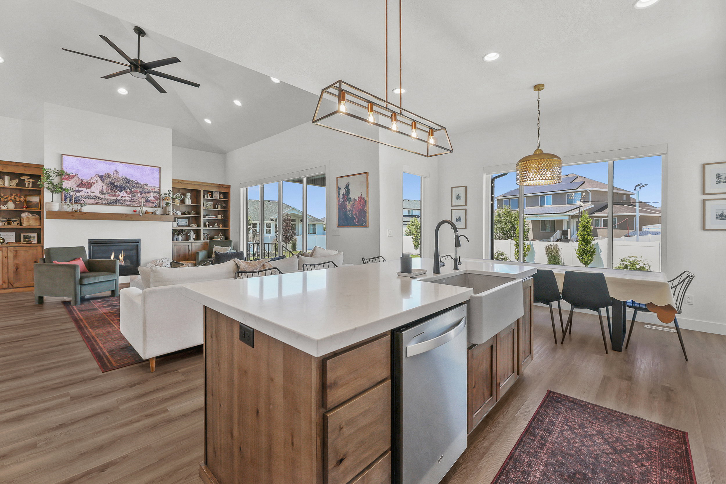 Open-concept kitchen and living area featuring a large center island with a white countertop and wood-finish cabinetry