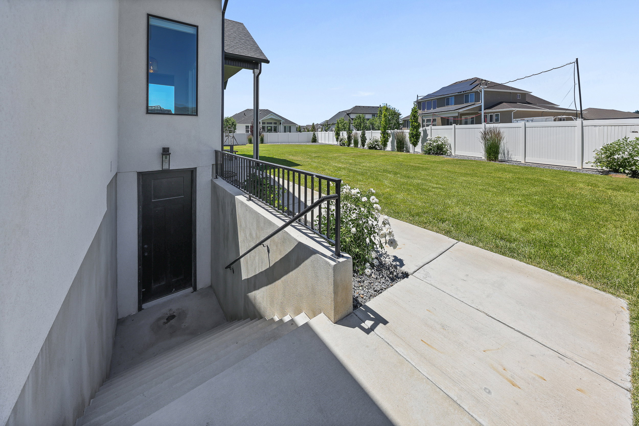 Exterior concrete stairs leading to a black door