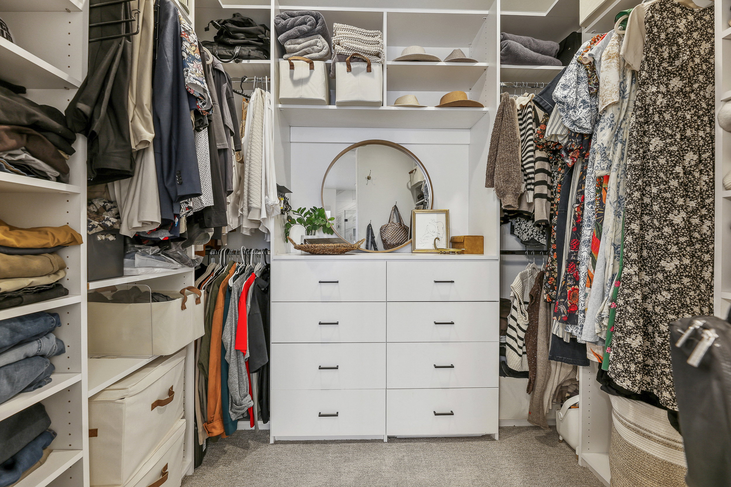 Custom closet system featuring white built-in cabinetry