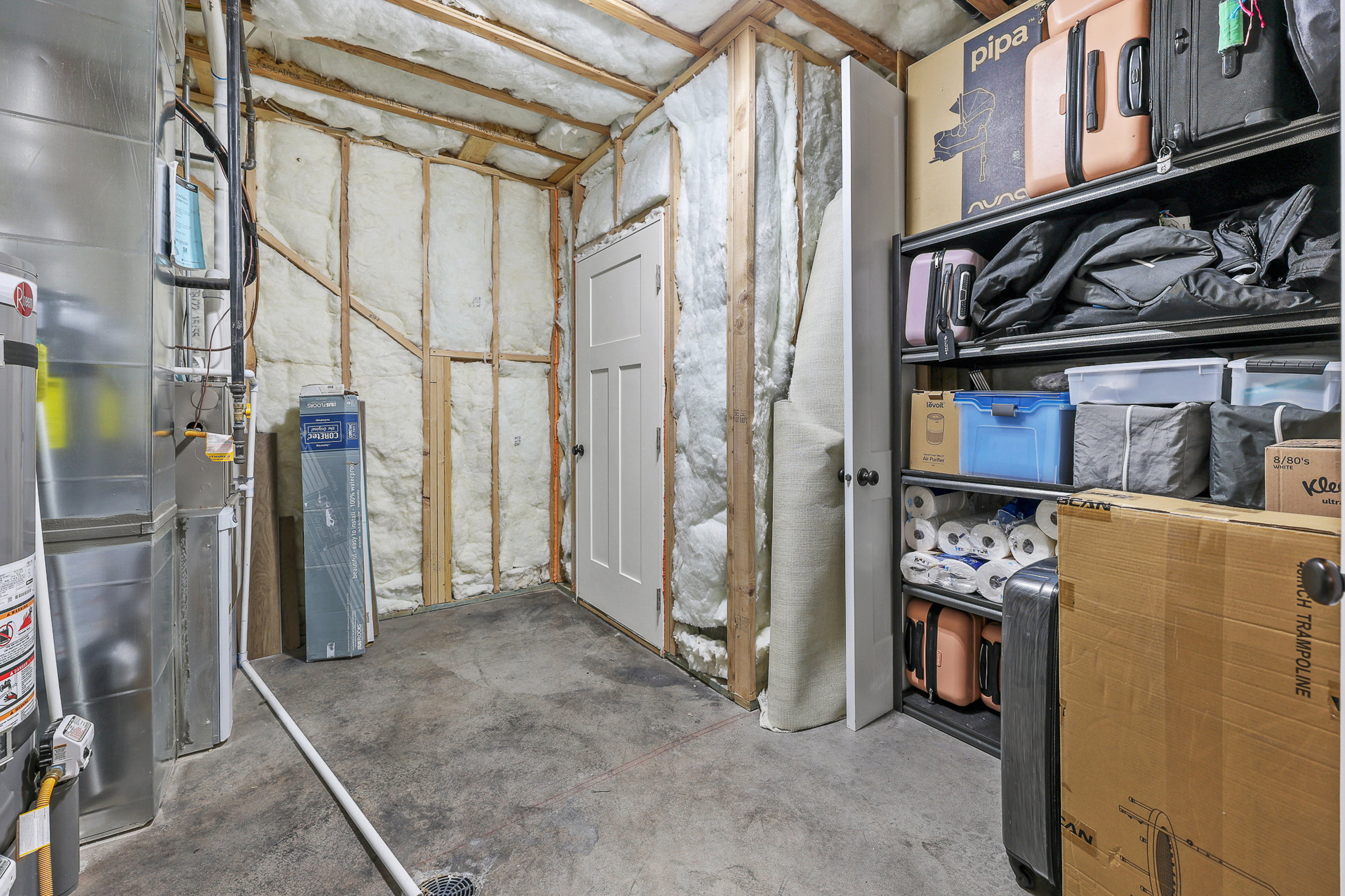 Unfinished basement area featuring exposed wood framing, insulation, and a concrete floor