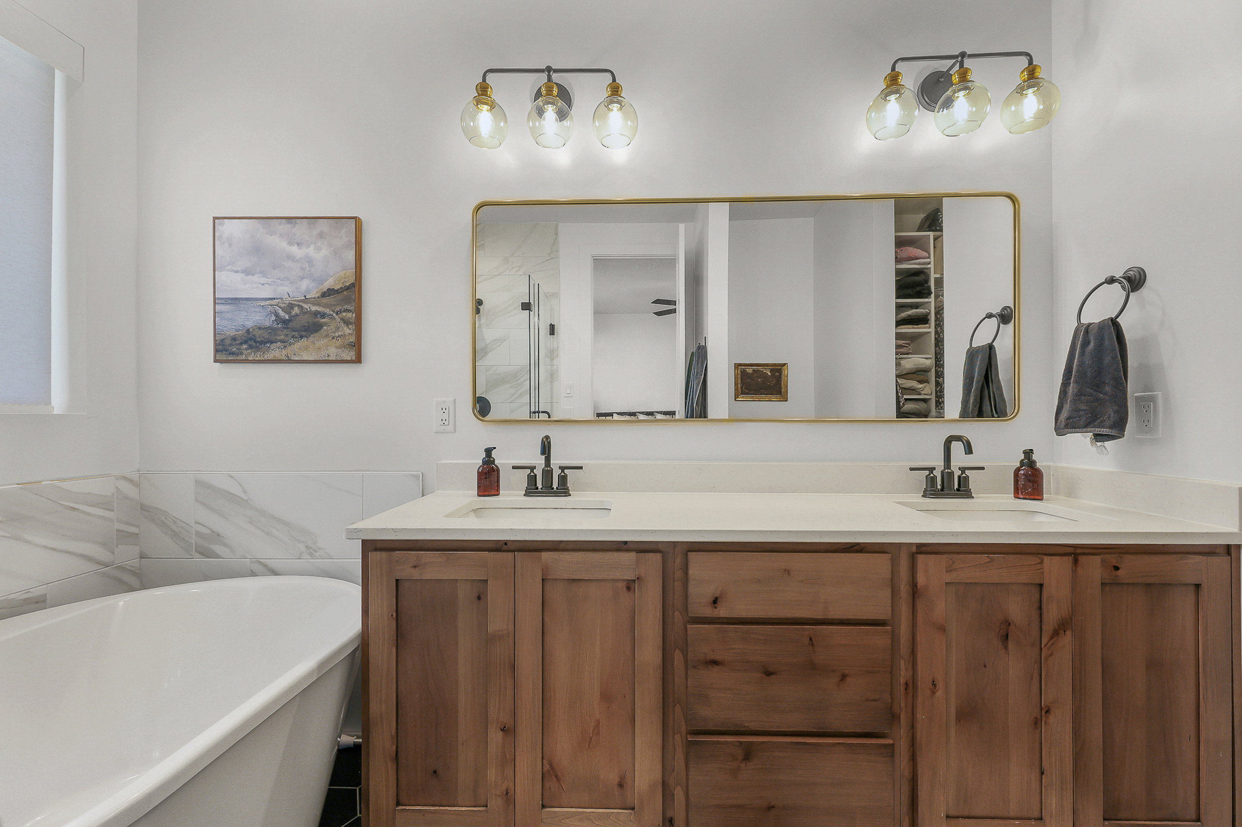 Double vanity with wood-finish cabinetry and white countertops