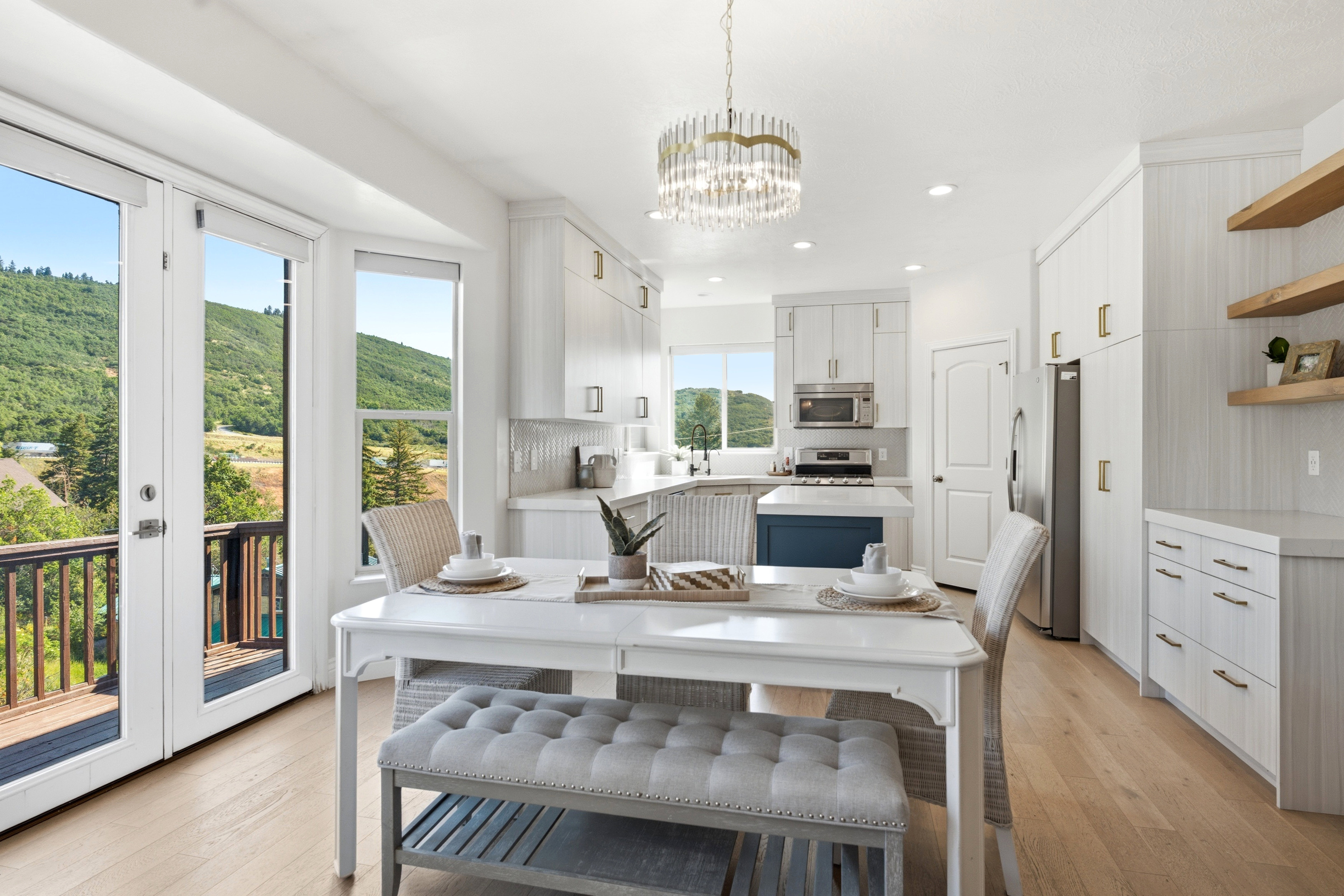 Bright kitchen with white cabinetry, stainless steel appliances, and a central island with a blue base