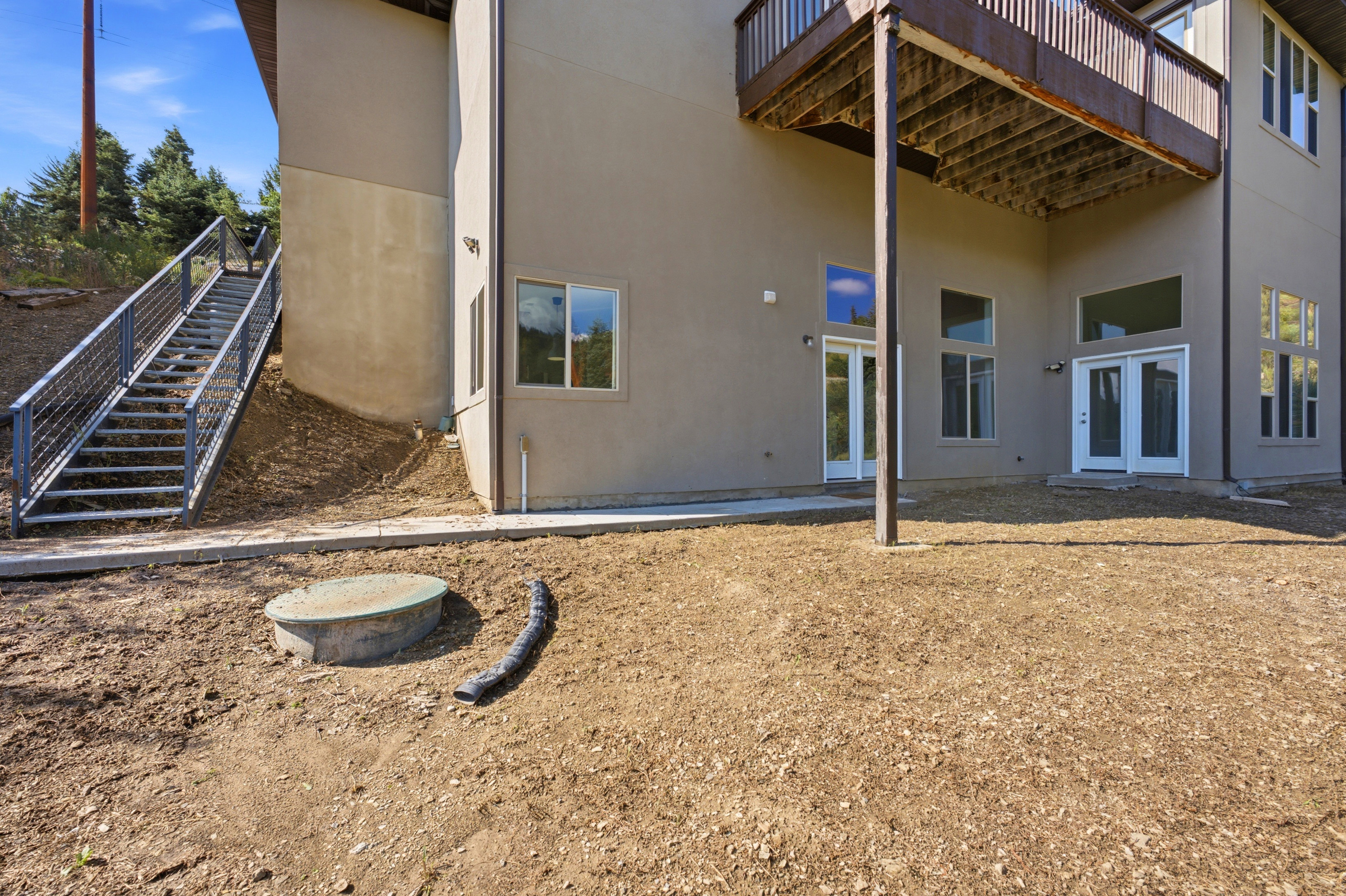 Side of the house and stairs to access the ADU externally along with the backyard patio.