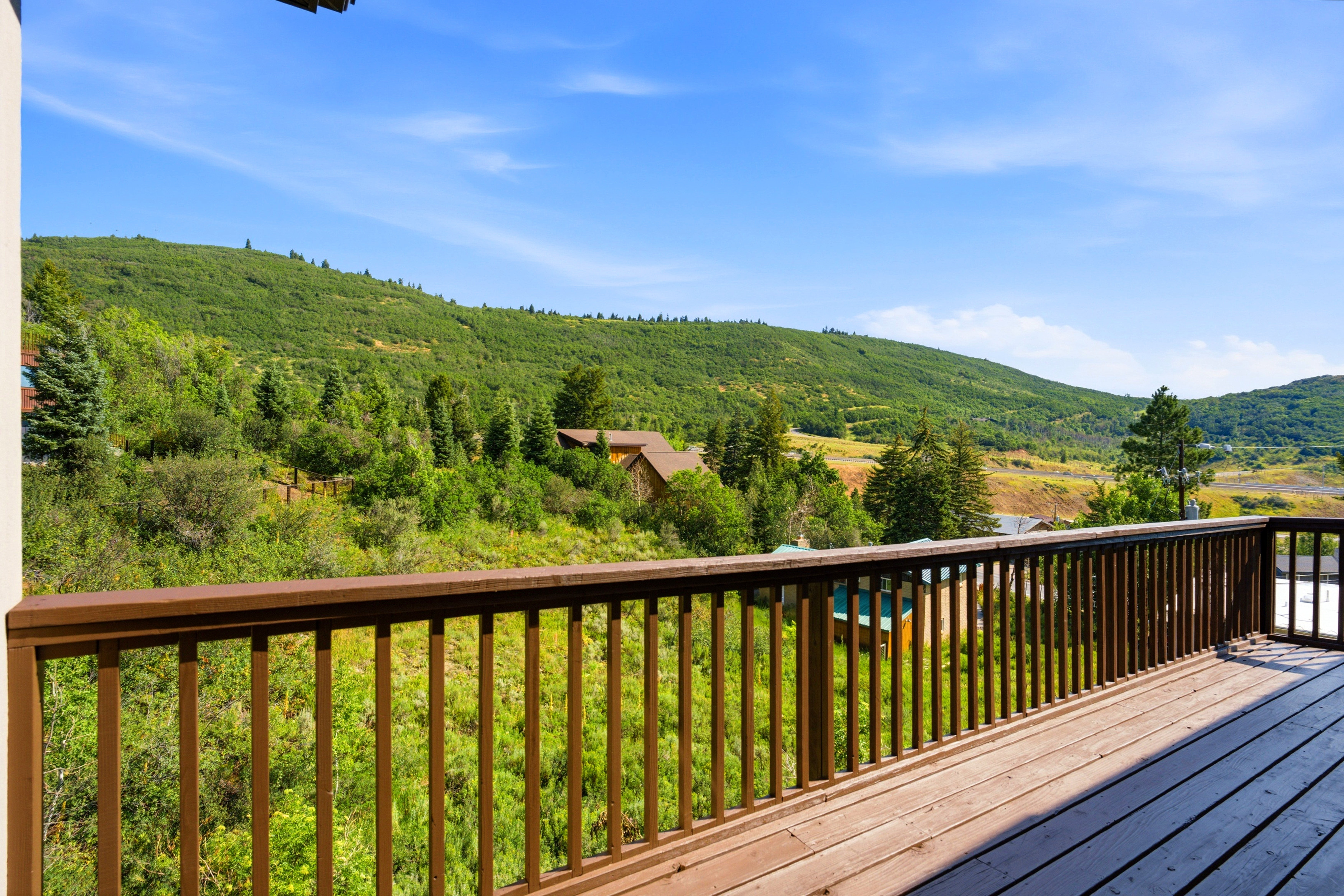 Expansive outdoor deck with wood-finish flooring and a wood railing system