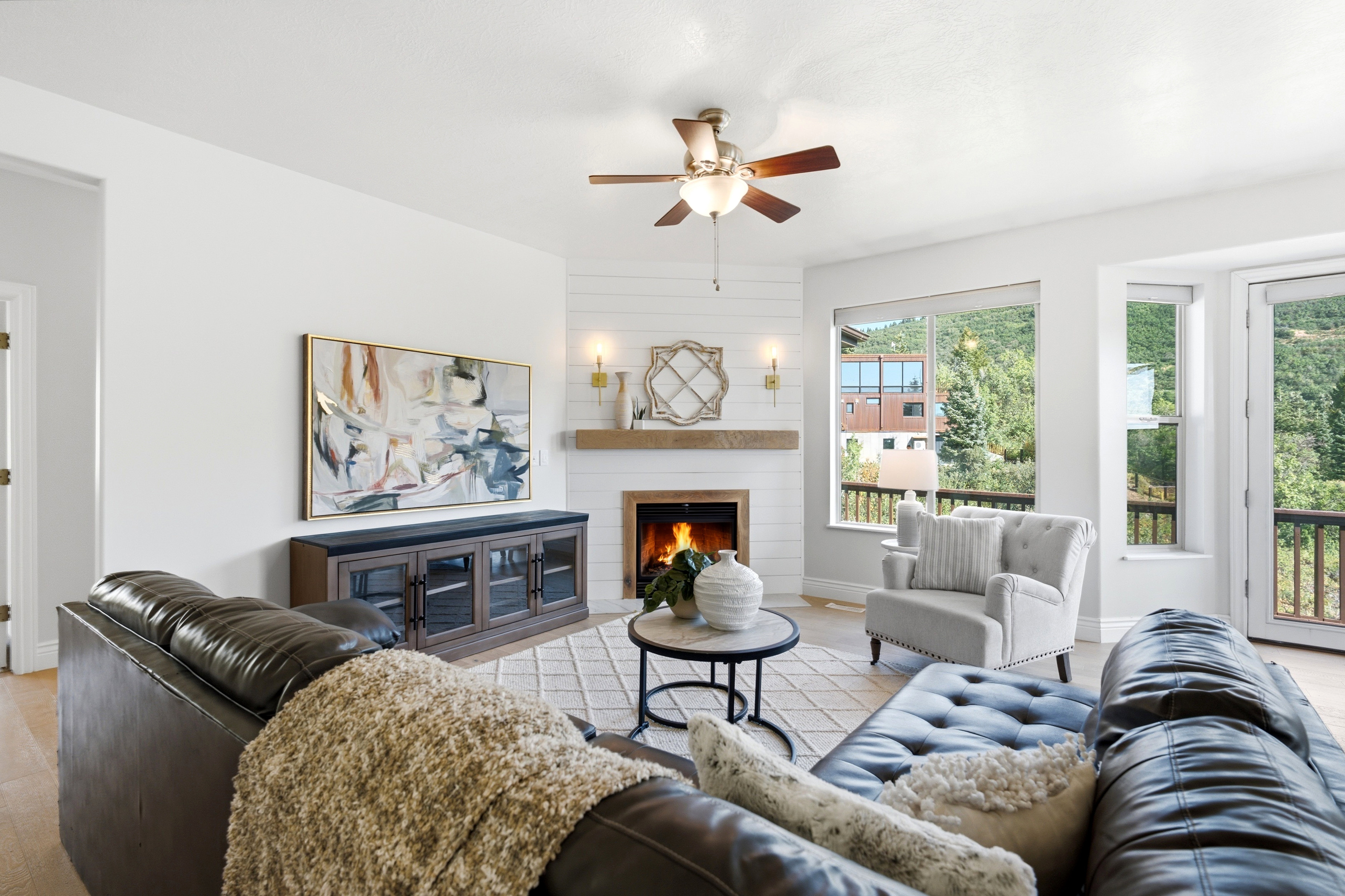 Living area featuring a fireplace with a wood mantle, shiplap surround, and wall sconces