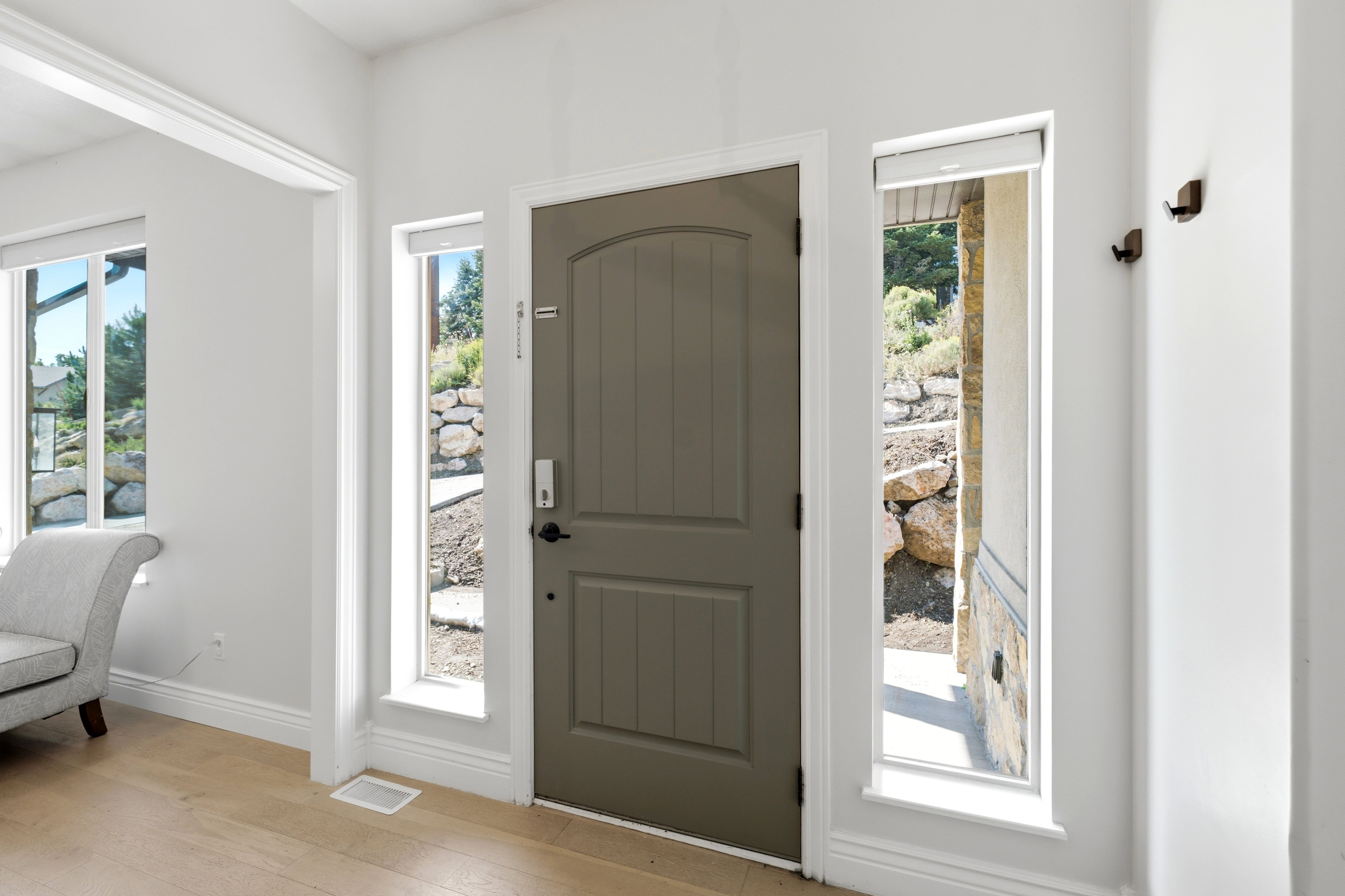Entryway featuring a paneled door, two sidelight windows, and light wood-finish flooring