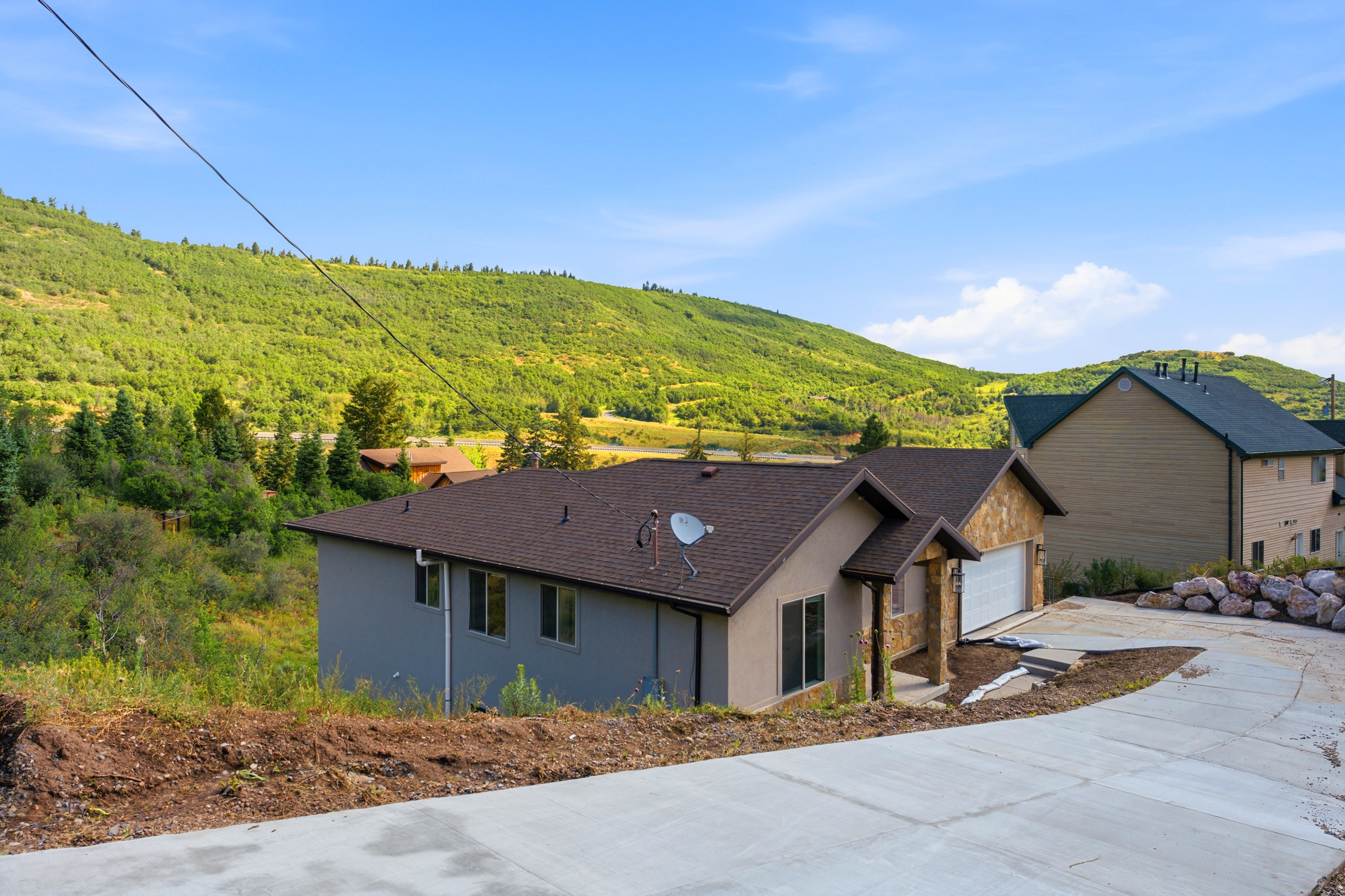 Contemporary home with a stone facade accent, an attached garage, and a concrete driveway