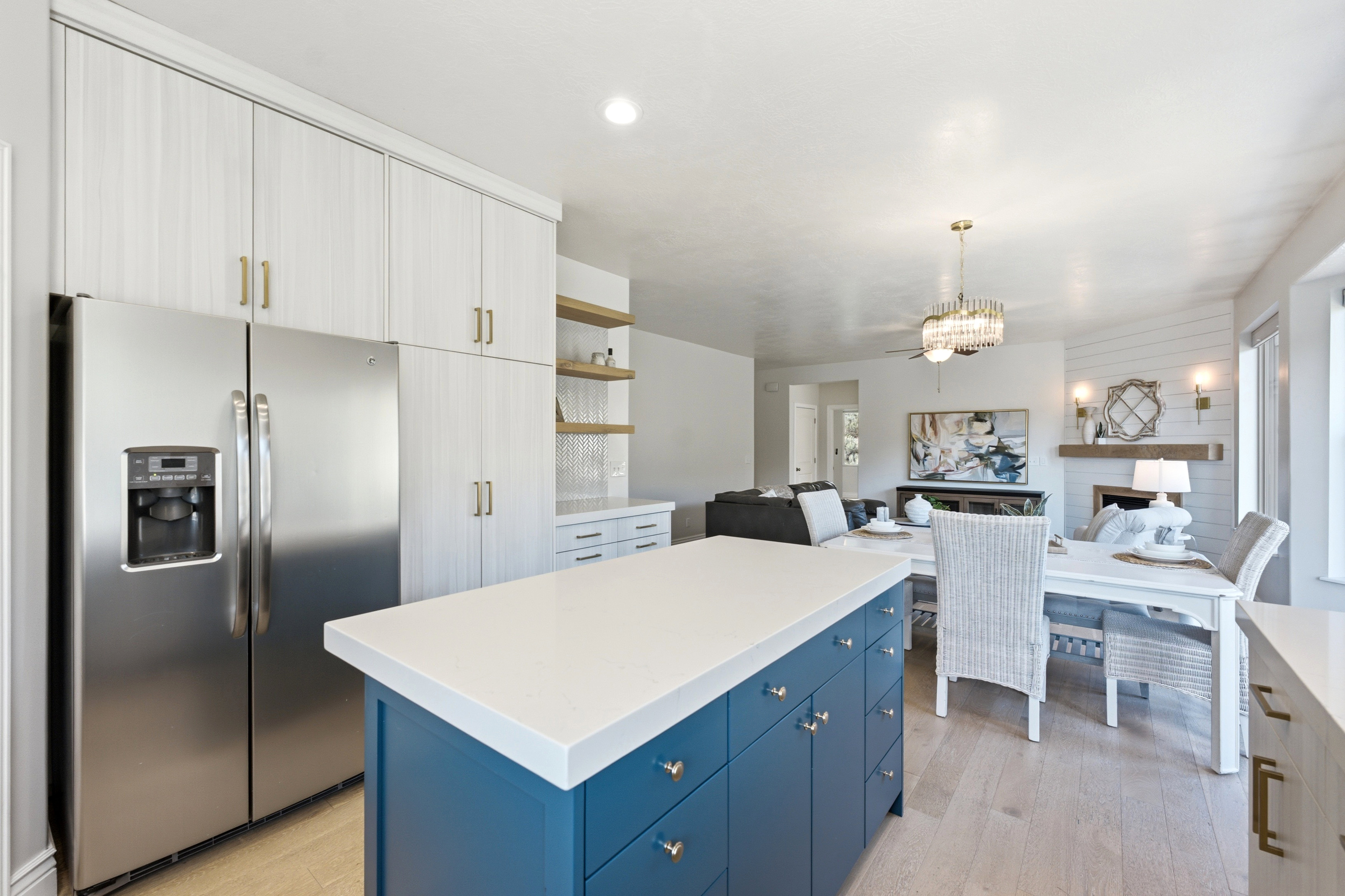Kitchen island featuring a white countertop and blue cabinetry with brass hardware