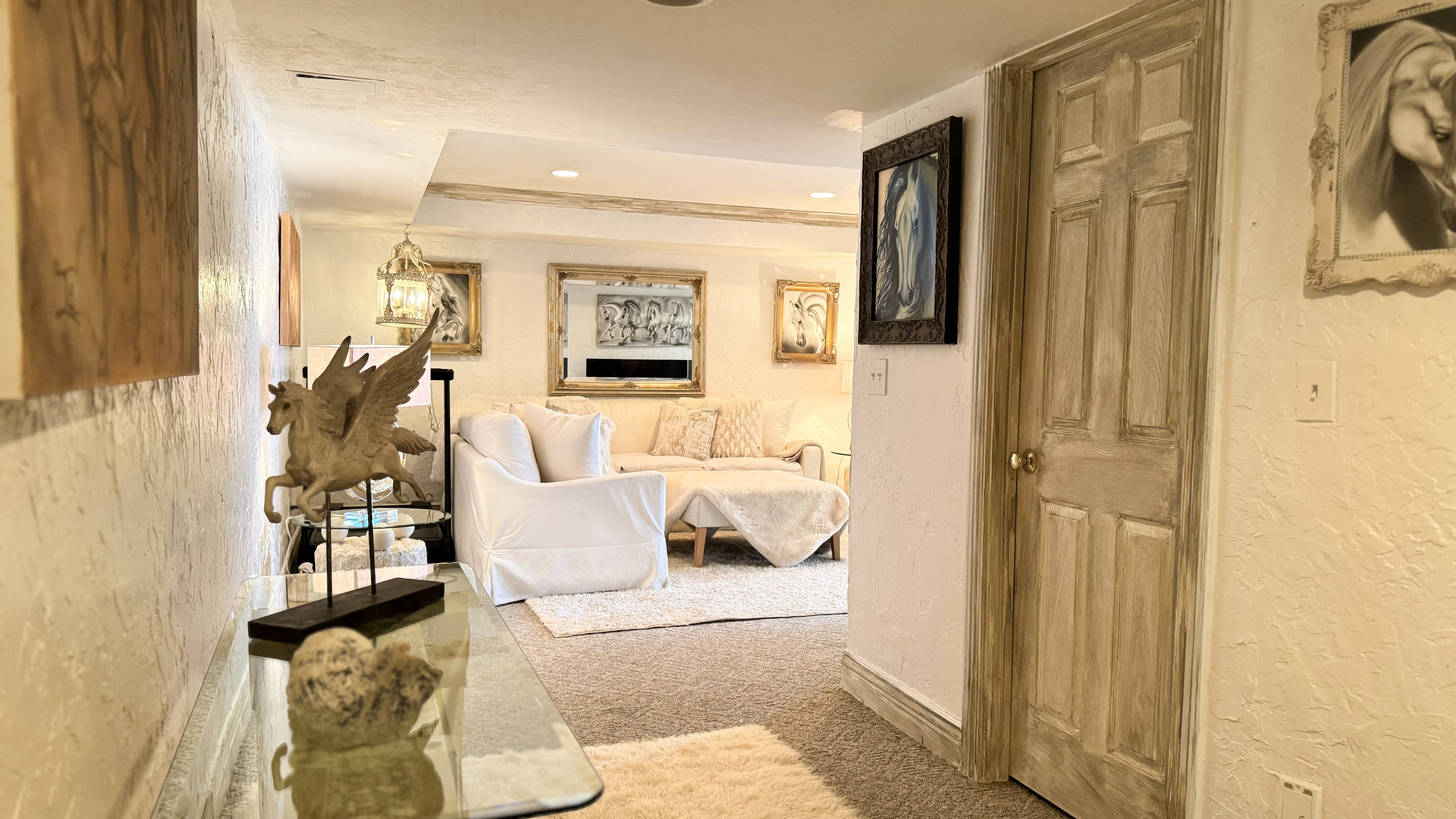 Carpeted interior area with textured walls and a paneled wooden door