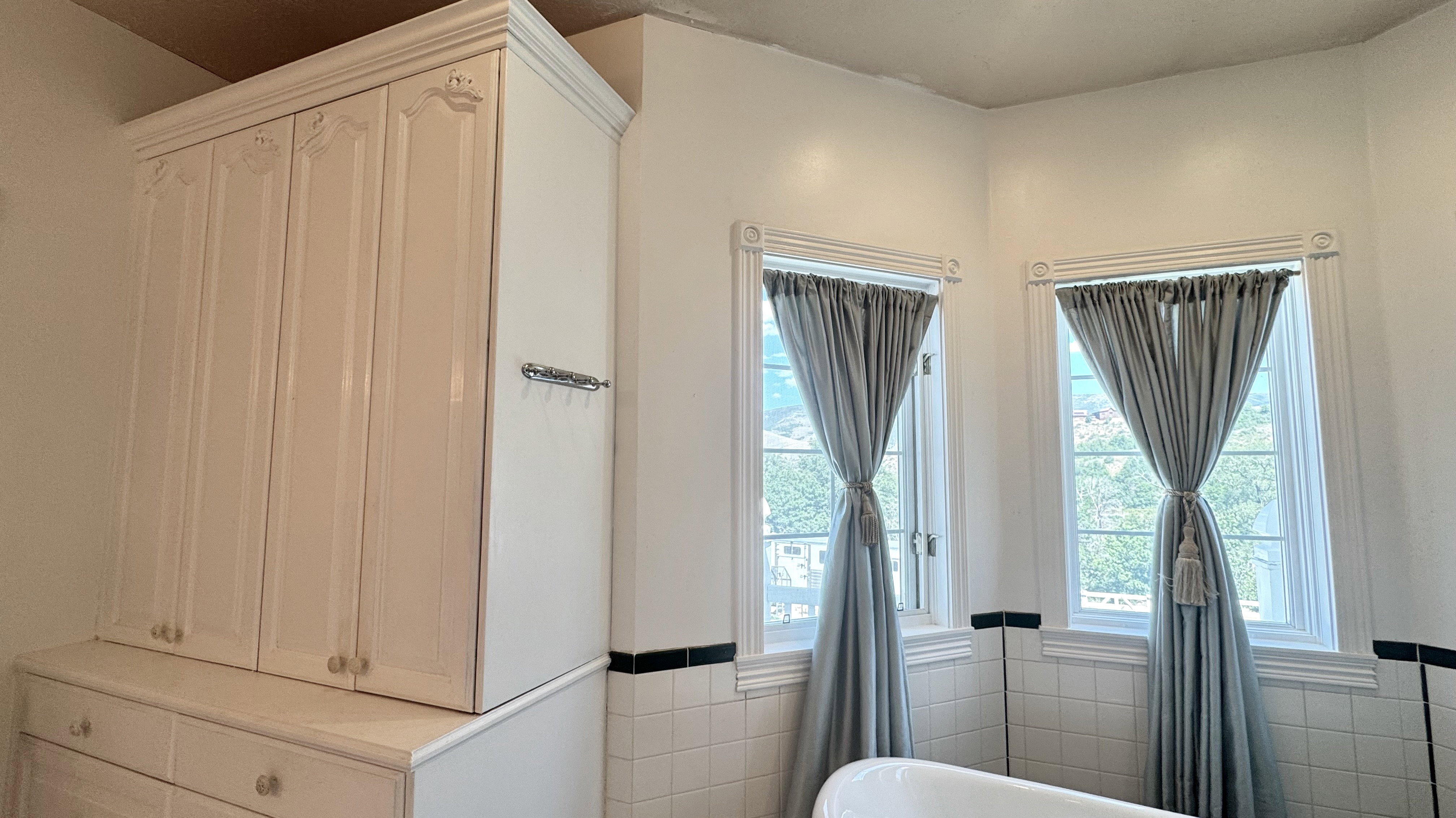 Built-in white cabinetry with decorative molding and clear knobs, featuring upper storage cabinets and lower drawers